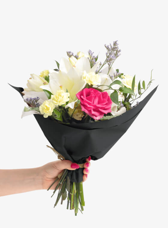 A hand holding black wax floral tissue paper