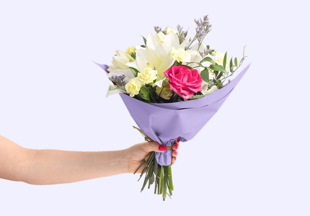 A hand holding lilac purple floral tissue paper