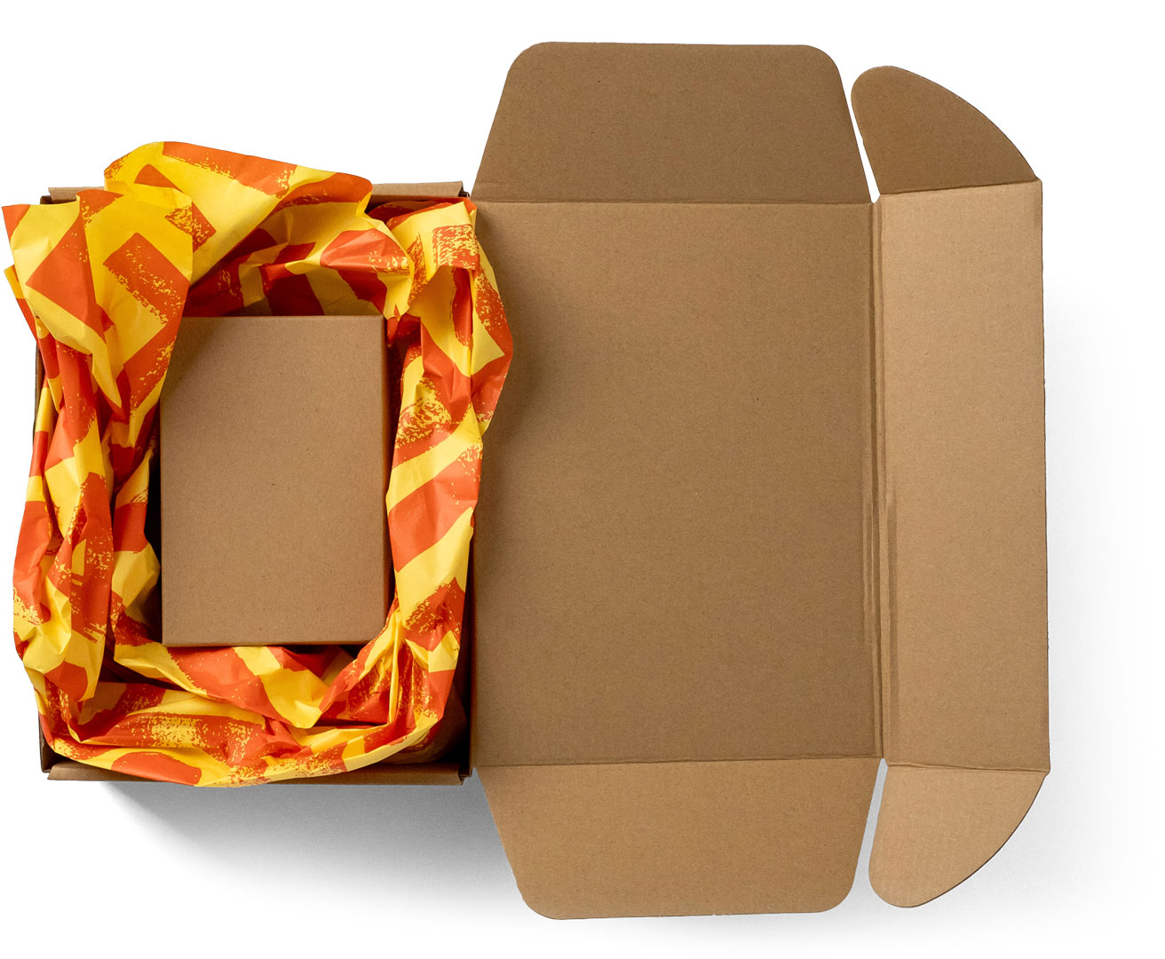 An open cardboard box with orange and yellow patterned packing paper and a smaller plain box inside it.
