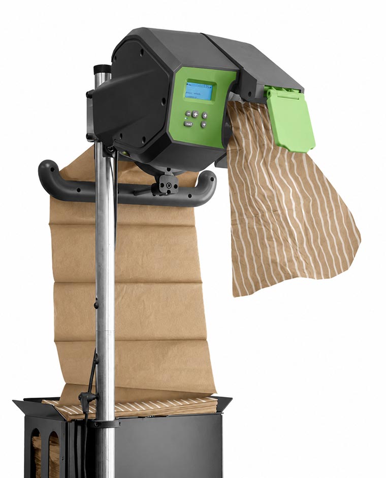 Industrial paper dispenser machine with a roll of brown kraft paper feeding through it, mounted on a metal pole with a black base, featuring a green digital control panel on the machine's black housing.