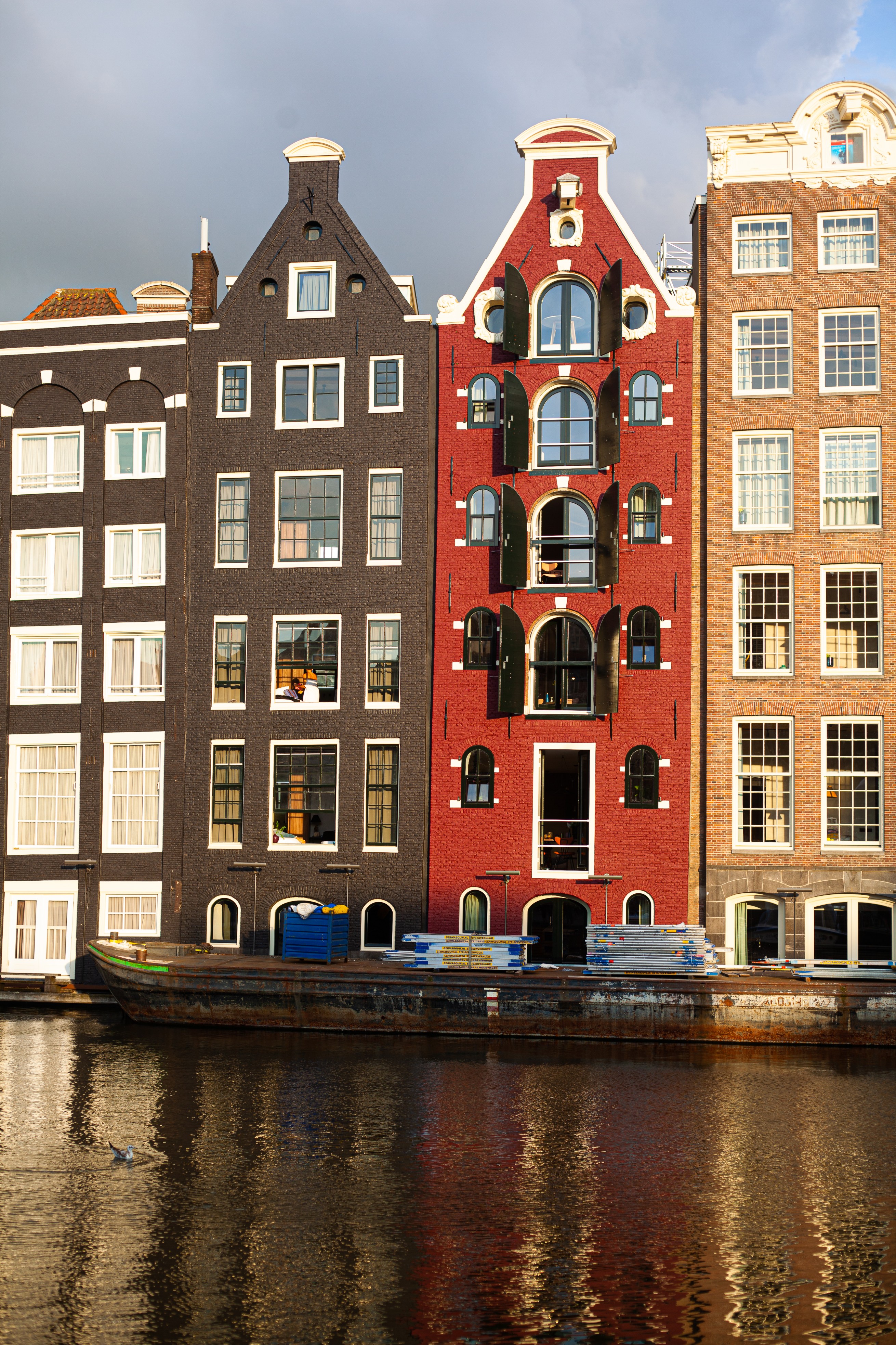 A row of houses along the canal in Amsterdam in the sunlight