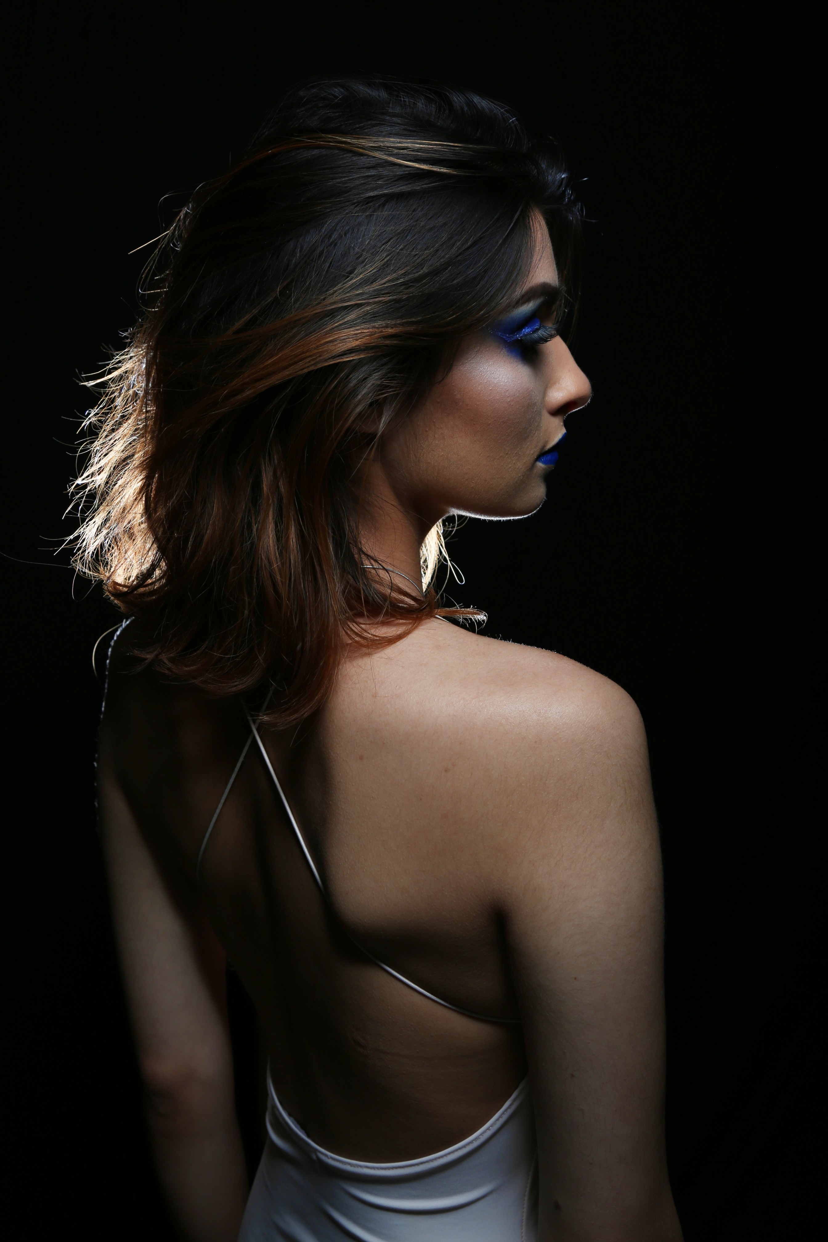 A portrait taken in a studio environment of a lady with blue makeup