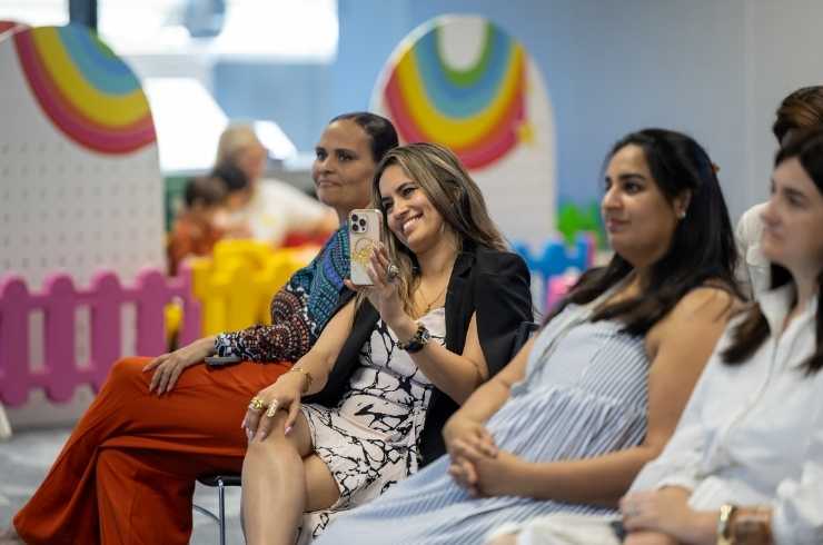 Concrete parking garage interior with an empty silver car parked on the left and marked handicapped parking spaces.