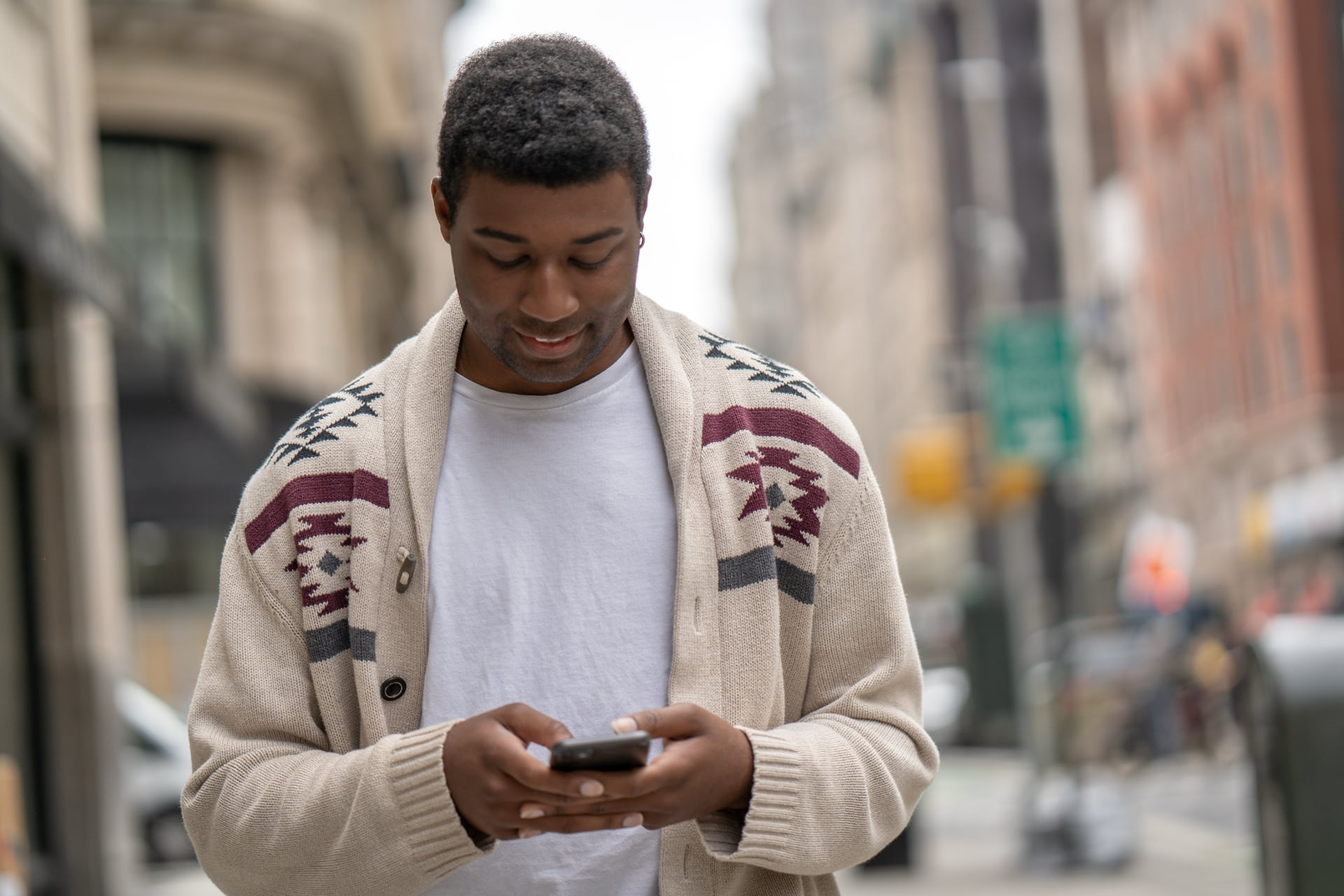 Man checking his phone on a New York City street.