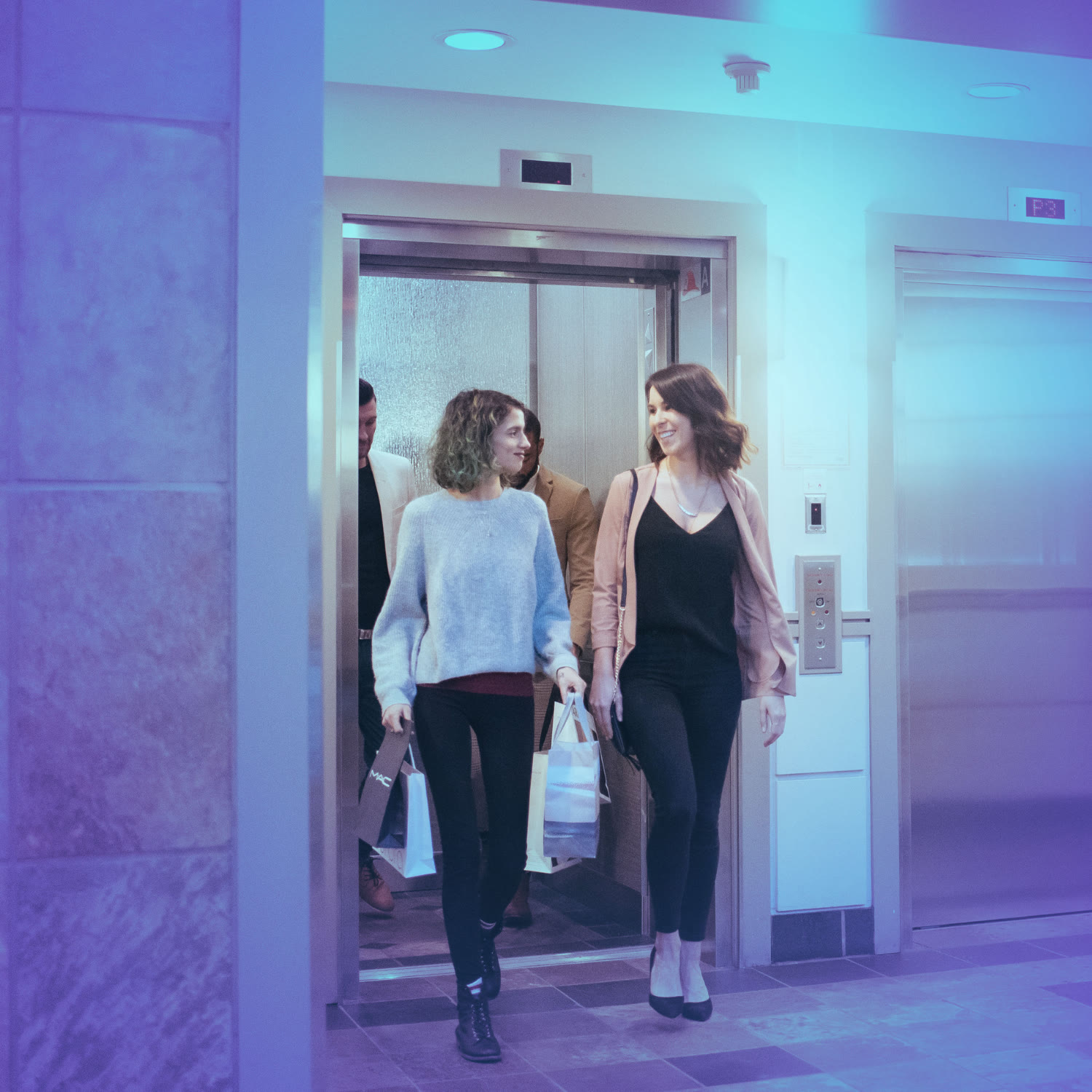 two people walking out of elevator