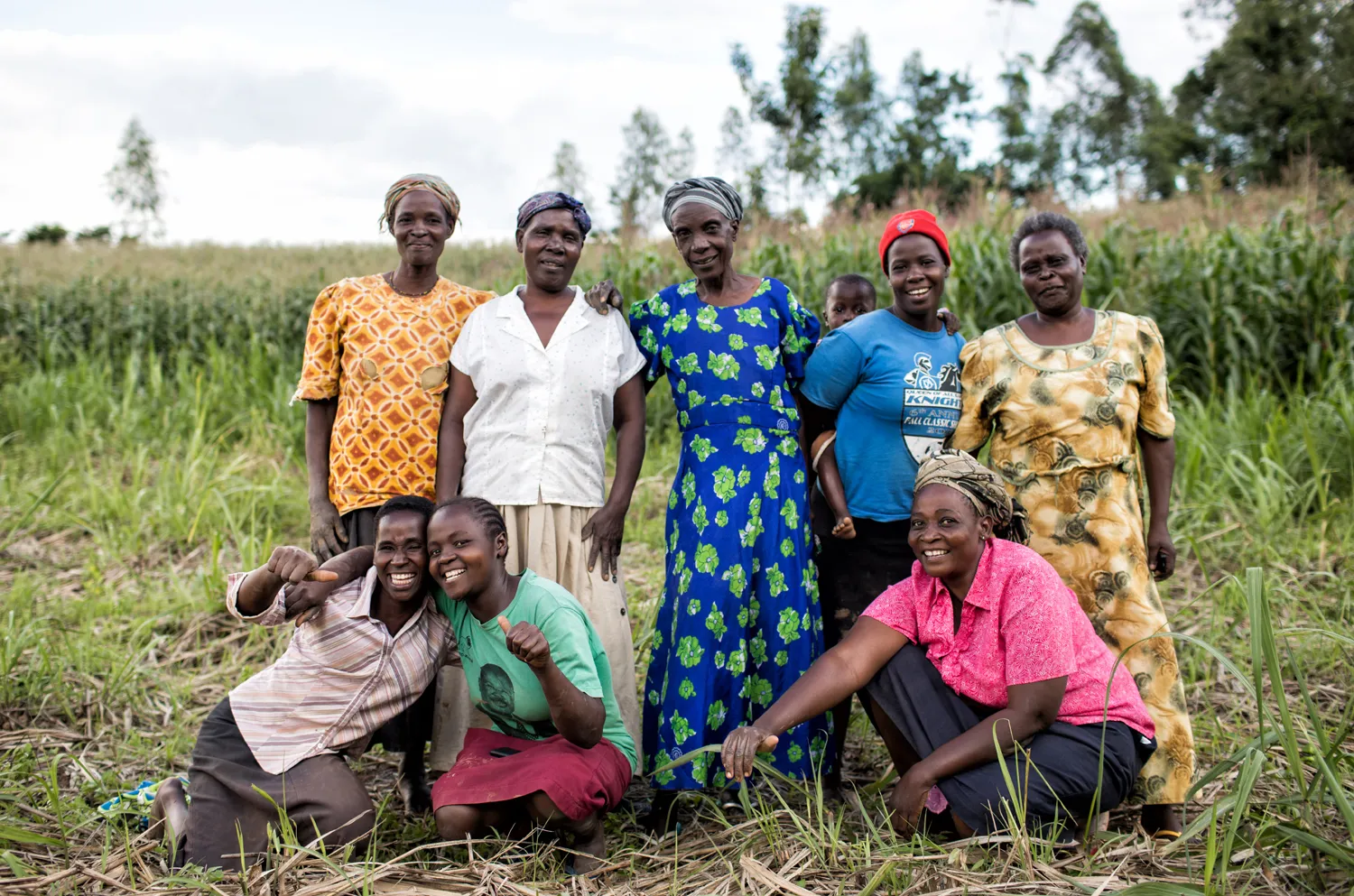 A group women gather together in celebration in an open field