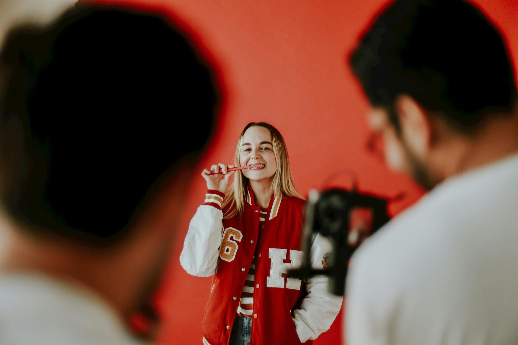 Smiling woman wearing a varsity jacket during a photoshoot