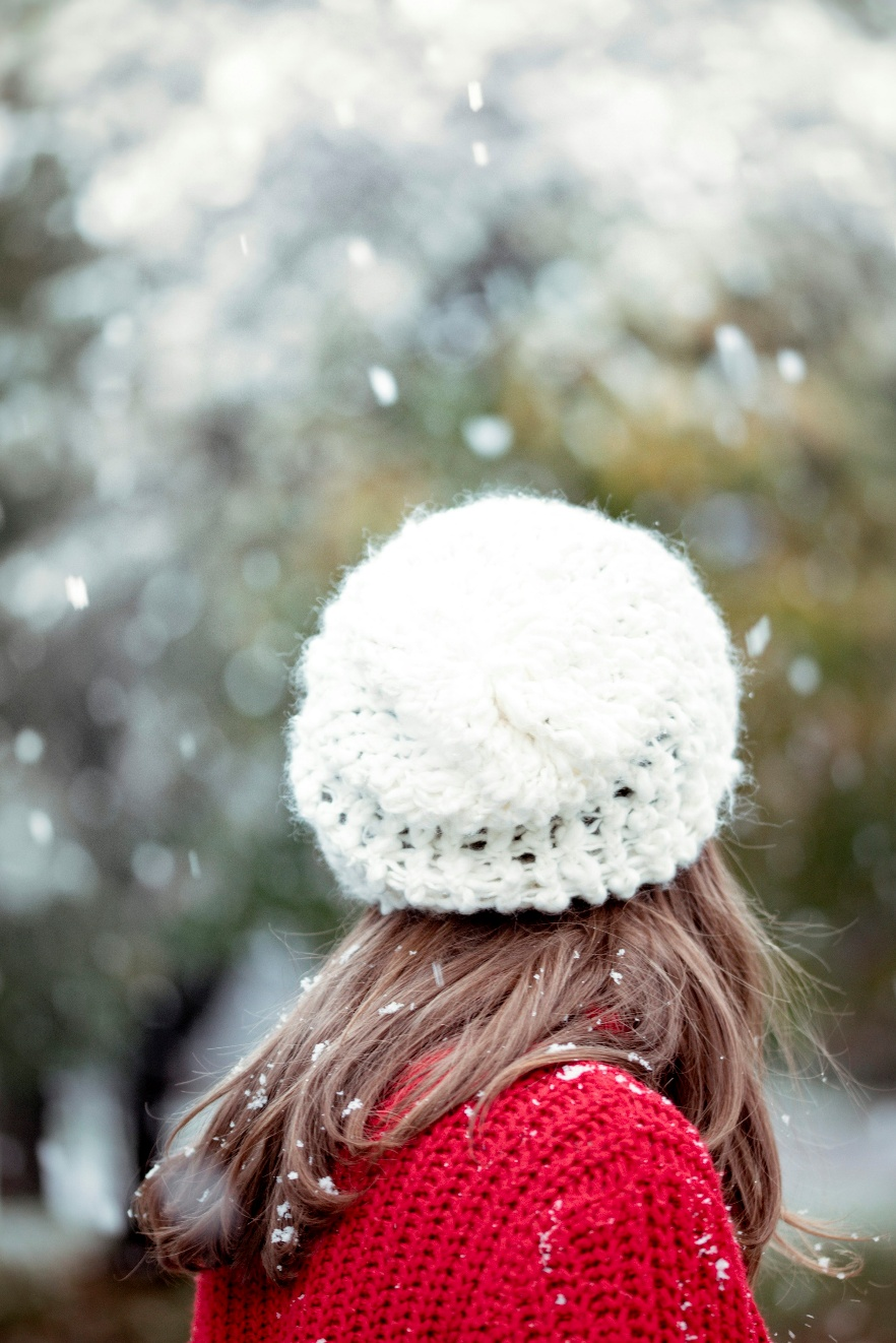 A girl in a red sweater and white hat