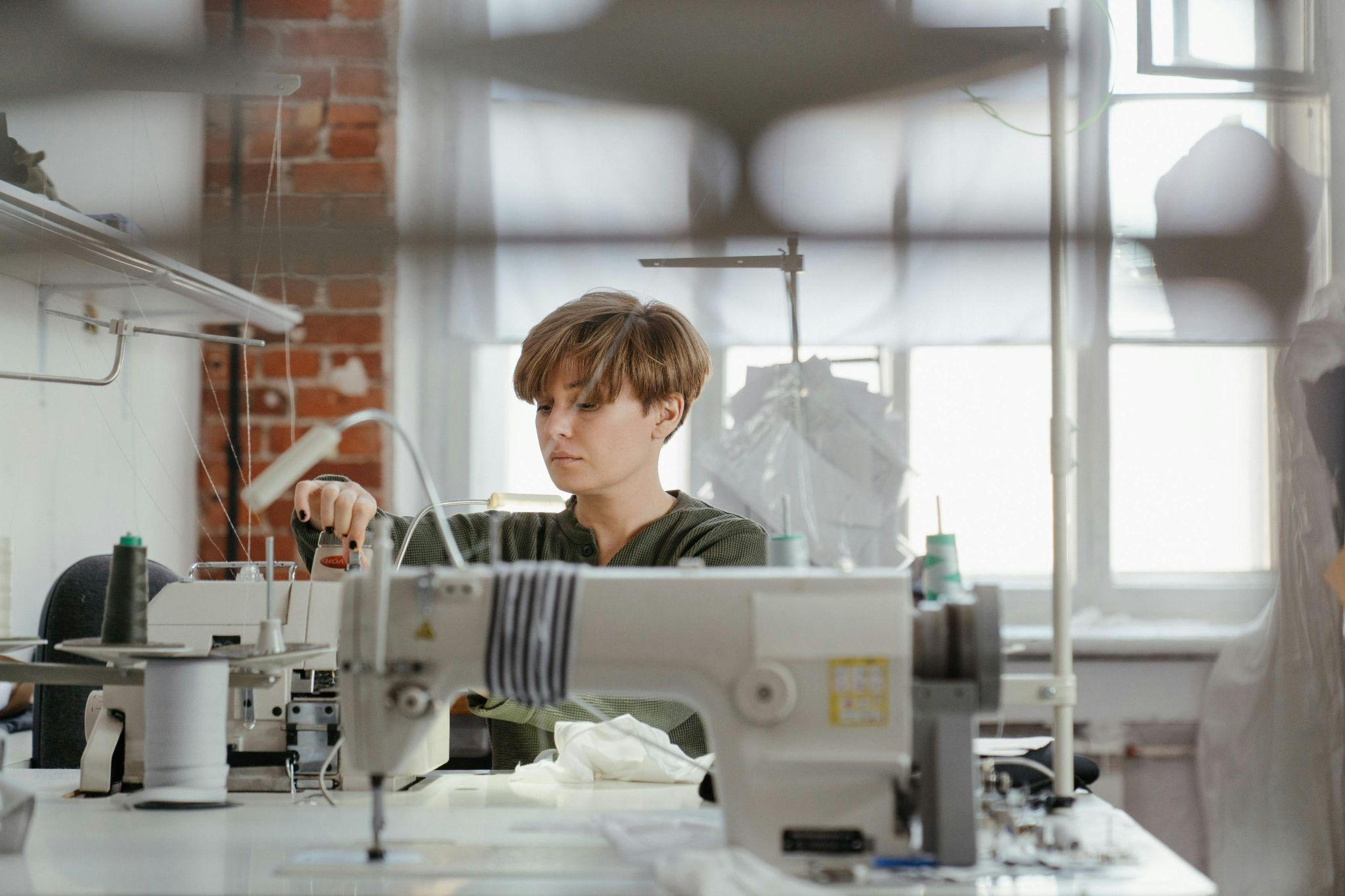 A garment worker sewing fabric using a sewing machine