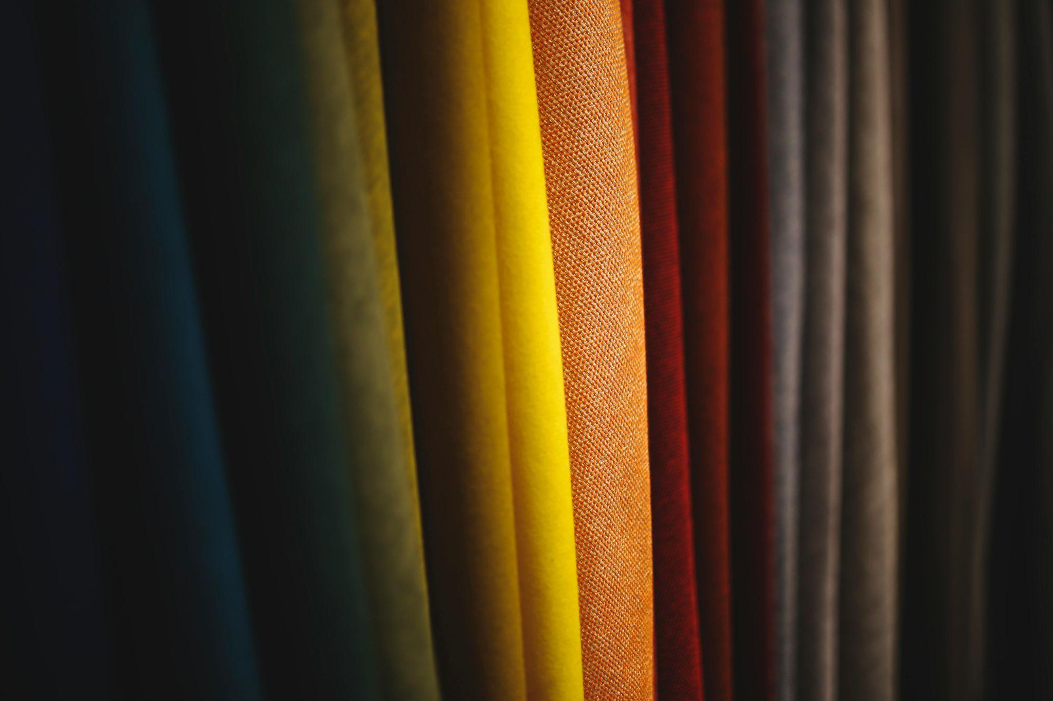 Colorful hanging fabric swatches displayed as material options for apparel sourcing