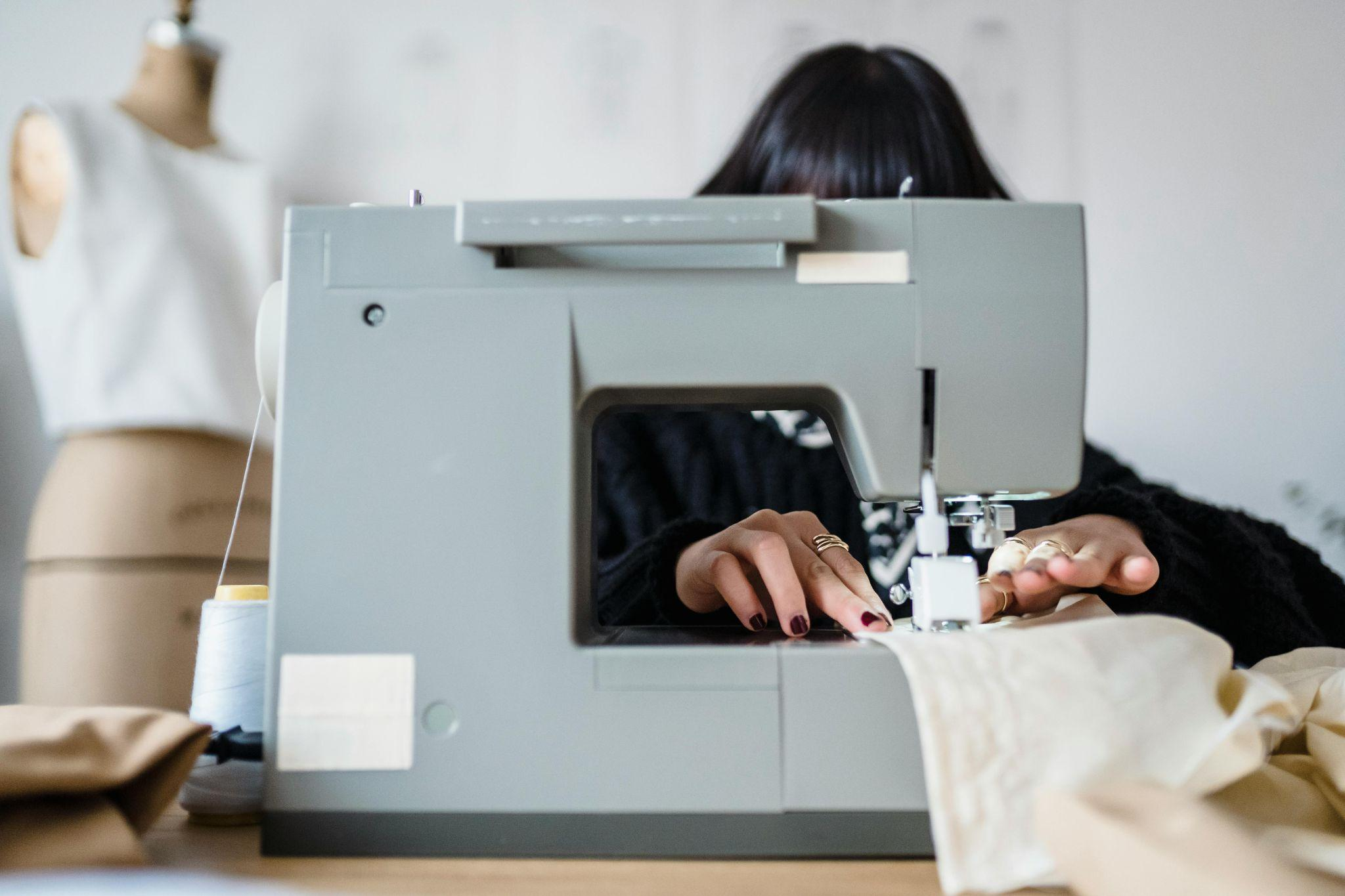 A woman sewing fabric at a sewing machine