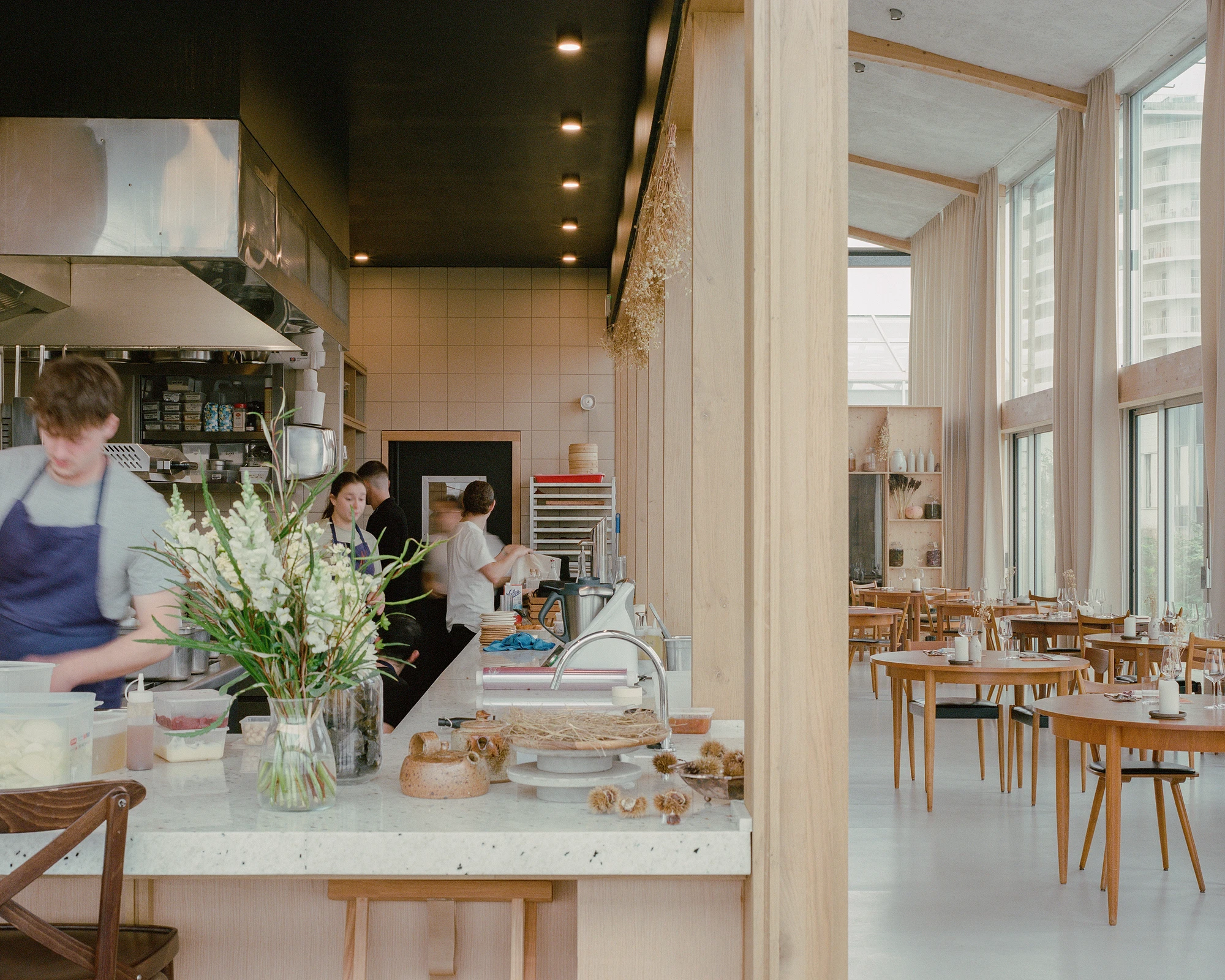 Restaurant Freia by Raum in Nantes France, glass greenhouse gourmet restaurant with rooftop garden on car park, minimalist interiors and cafe design