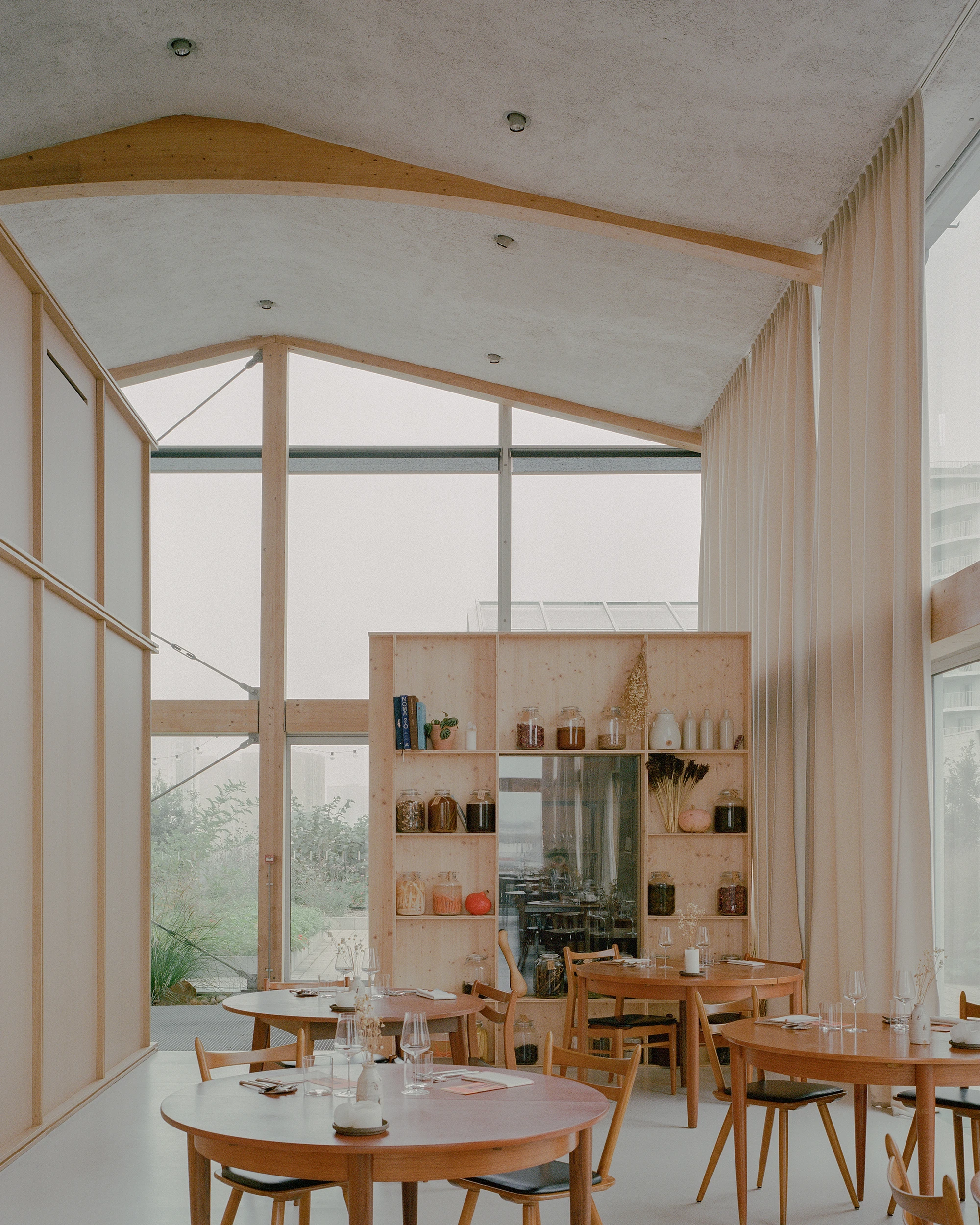 Restaurant Freia by Raum in Nantes France, glass greenhouse gourmet restaurant with rooftop garden on car park, minimalist interiors and cafe design