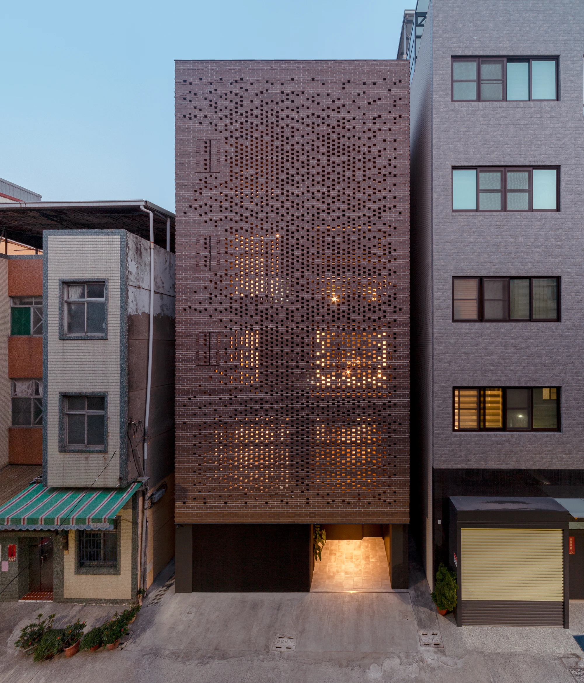 The Veil House by Paperfarm Inc in Kaohsiung Taiwan, perforated clay-brick facade filtering light, minimalist family house architecture with brick and garden