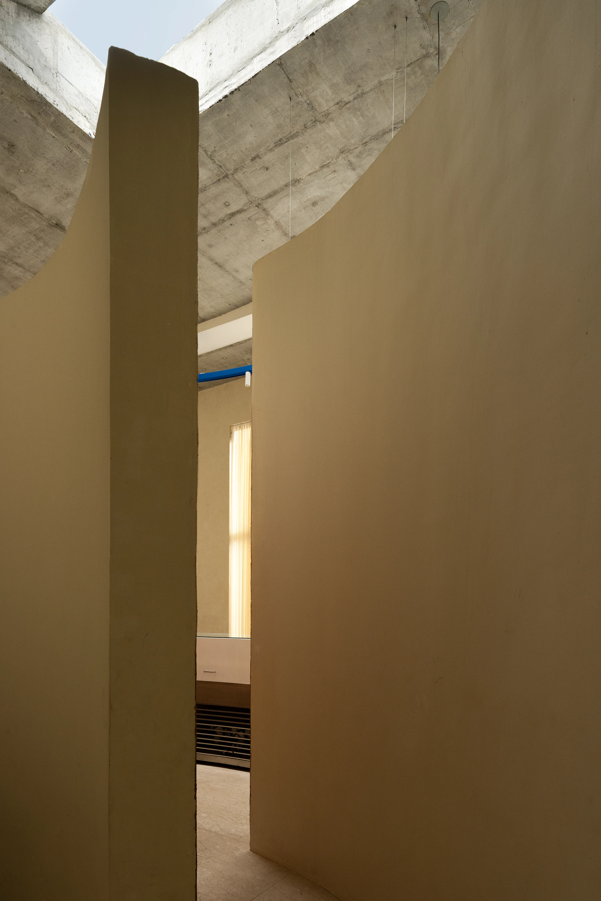 Eventide Coffee by BILLBOARDS in Chennai India, coastal cafe interior with elliptical counter and skylight, earthy tones and curved architectural elements inspired by the Madras beach