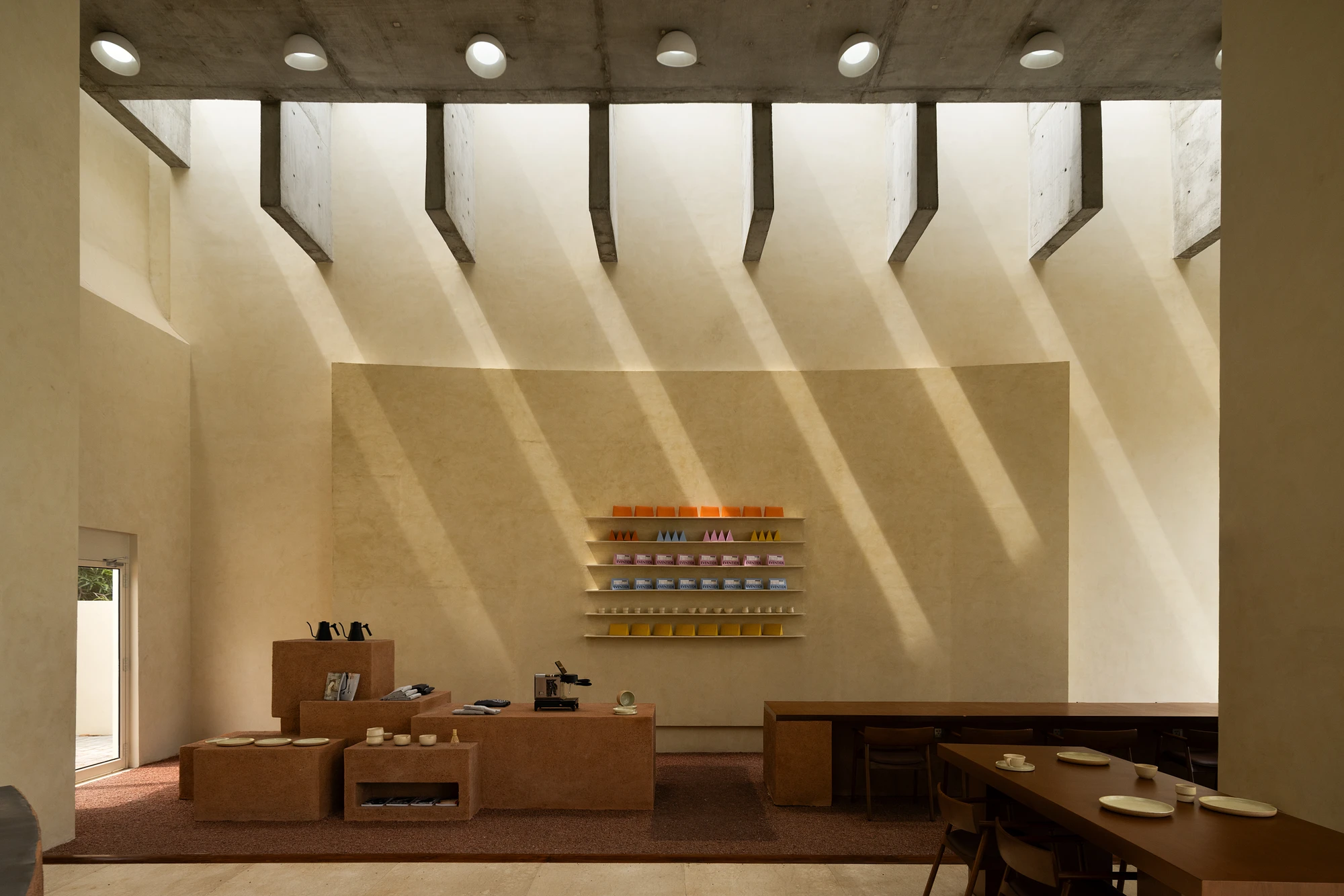 Eventide Coffee by BILLBOARDS in Chennai India, coastal cafe interior with elliptical counter and skylight, earthy tones and curved architectural elements inspired by the Madras beach