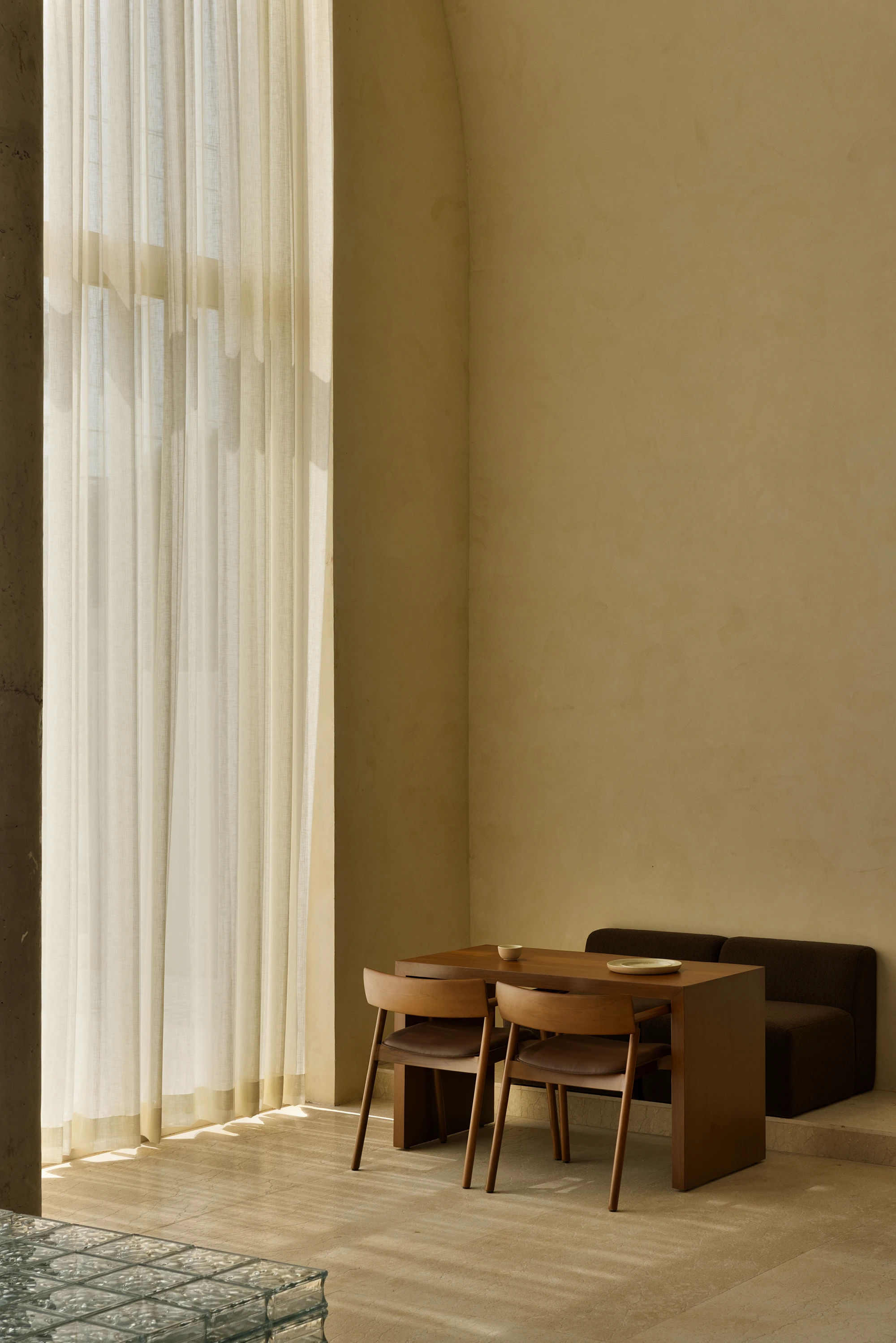 Eventide Coffee by BILLBOARDS in Chennai India, coastal cafe interior with elliptical counter and skylight, earthy tones and curved architectural elements inspired by the Madras beach