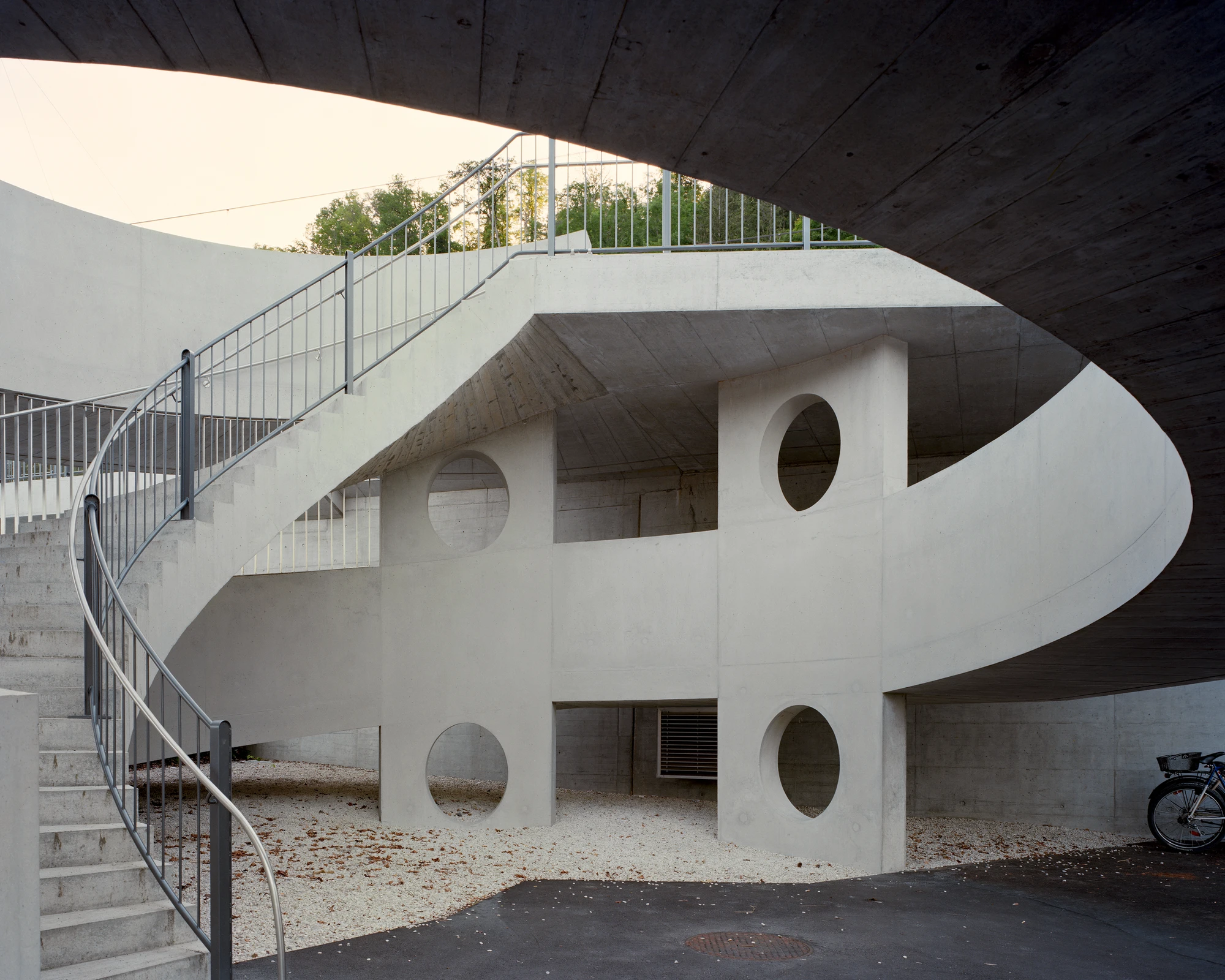 BLT Linie 19 Hölstein Süd tram stop by Raeto Studer Architekten in Switzerland, exposed concrete ramp and staircase infrastructure with 540-degree spiral and 55m concrete girder