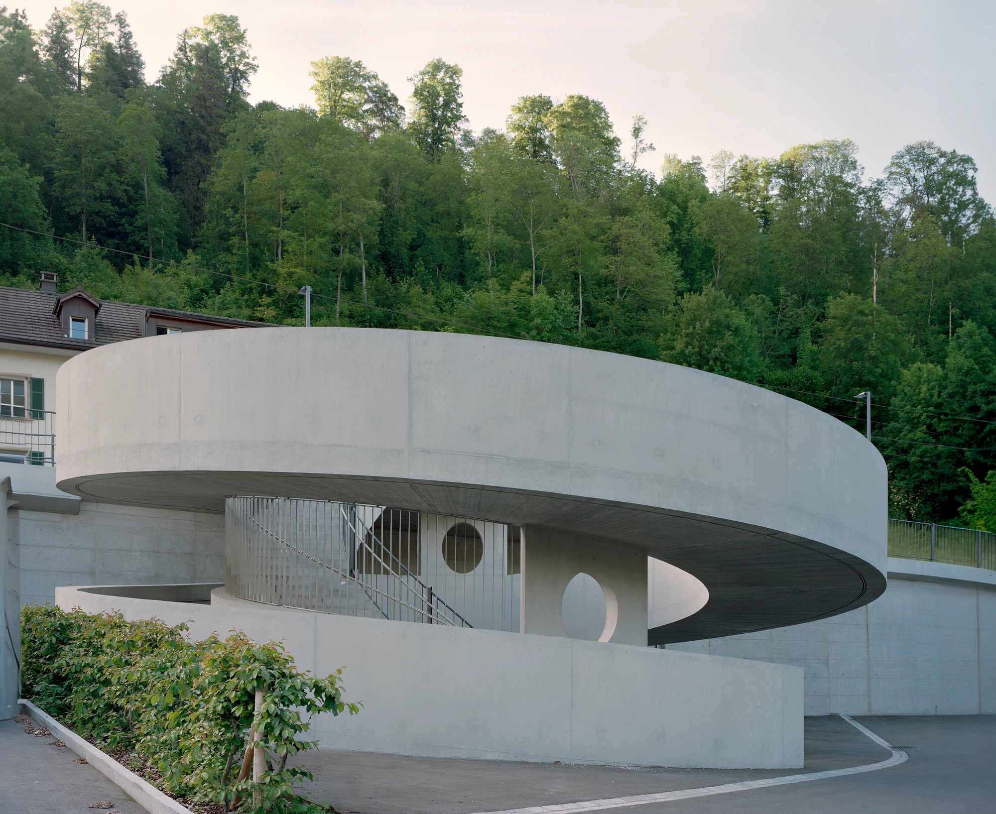 BLT Linie 19 Hölstein Süd tram stop by Raeto Studer Architekten in Switzerland, exposed concrete ramp and staircase infrastructure with 540-degree spiral and 55m concrete girder