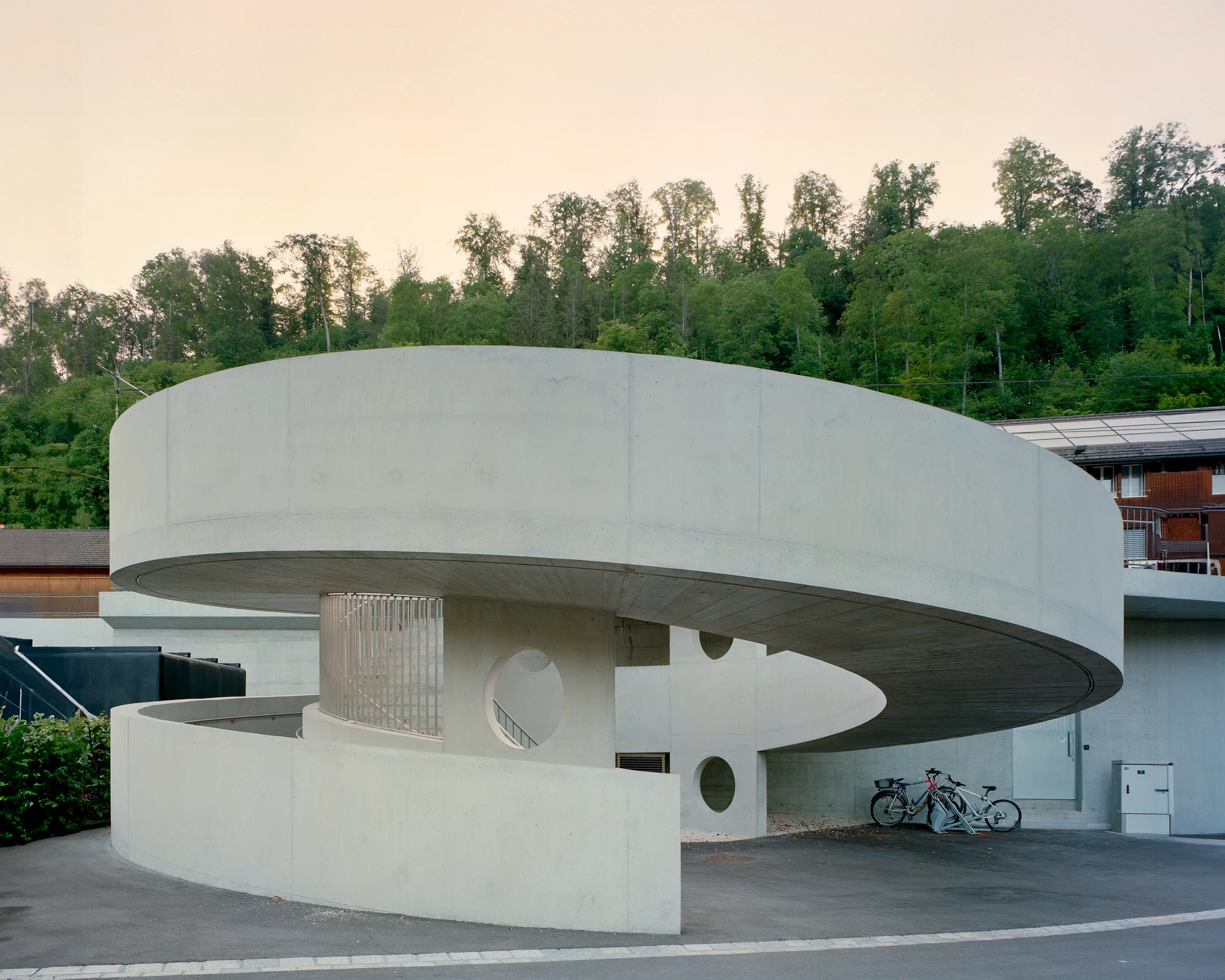 BLT Linie 19 Hölstein Süd tram stop by Raeto Studer Architekten in Switzerland, exposed concrete ramp and staircase infrastructure with 540-degree spiral and 55m concrete girder