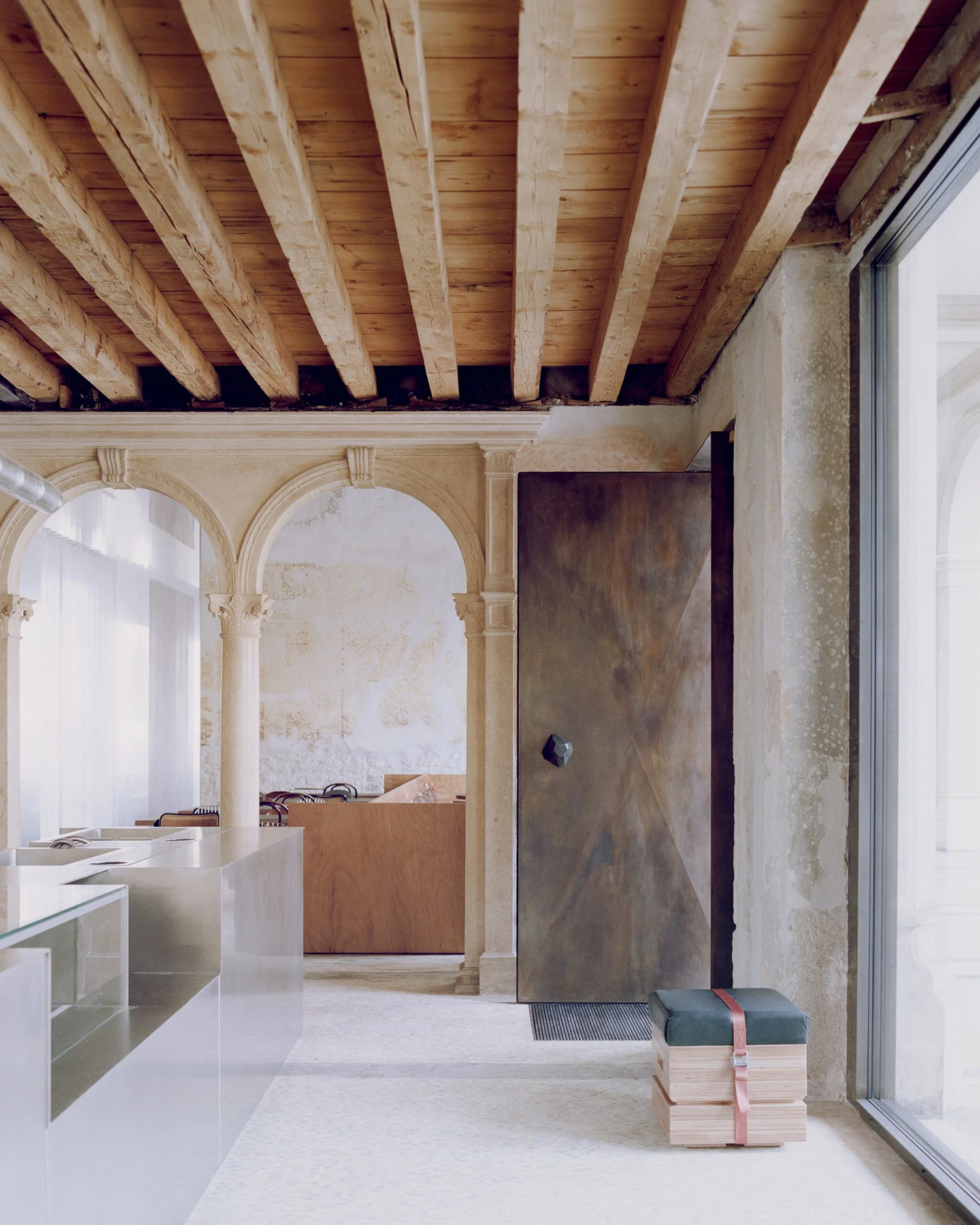 Caffè Nazionale by AMAA in Arzignano Italy, adaptive reuse of 19th-century palazzo with pleated stainless steel walls, okumè plywood ceiling and preserved historical patinas