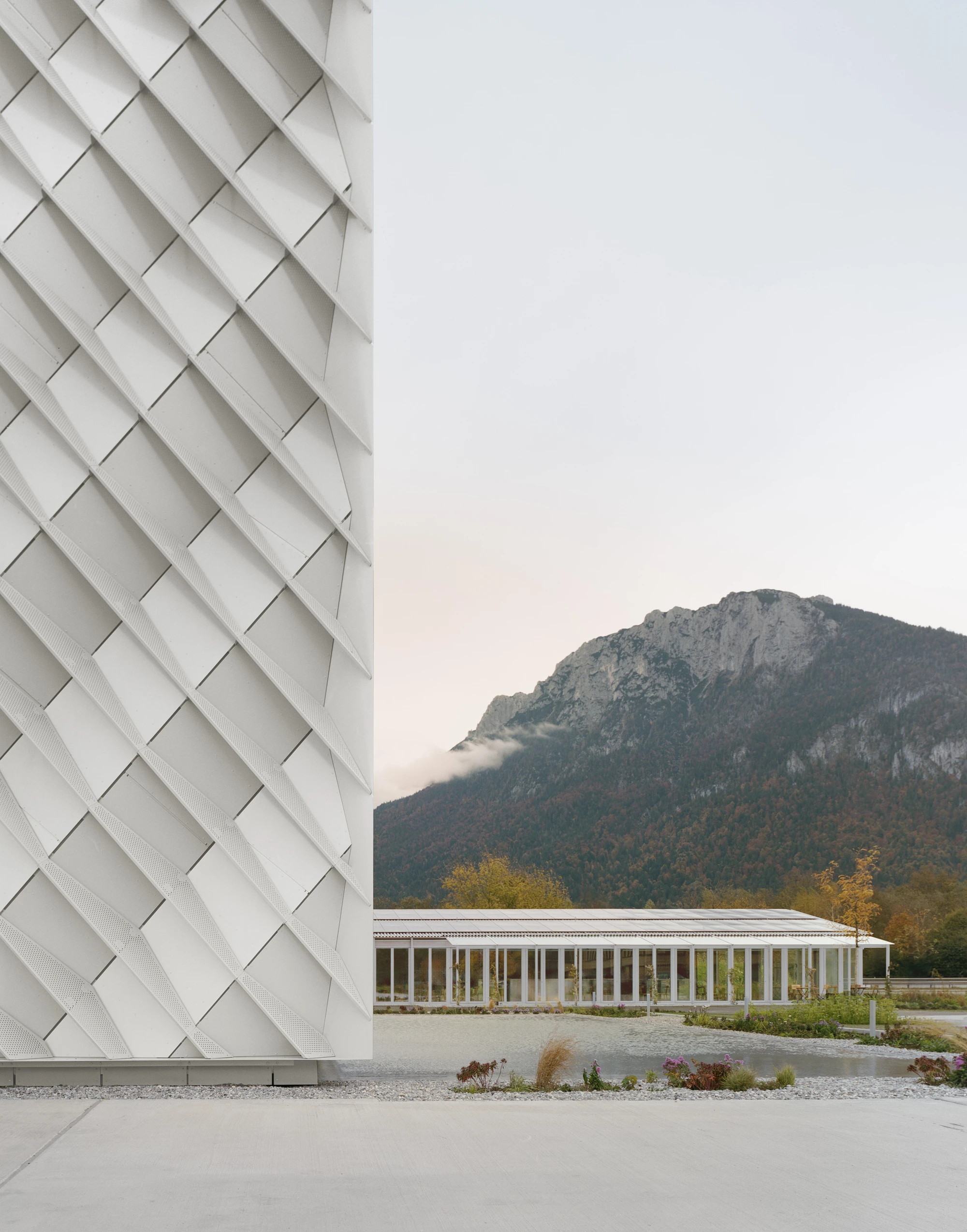 Dynafit Headquarters Speedfactory by Barozzi Veiga in Kiefersfelden Germany, twin pyramidal corporate building with diagonal metal lattice facade set against alpine landscape
