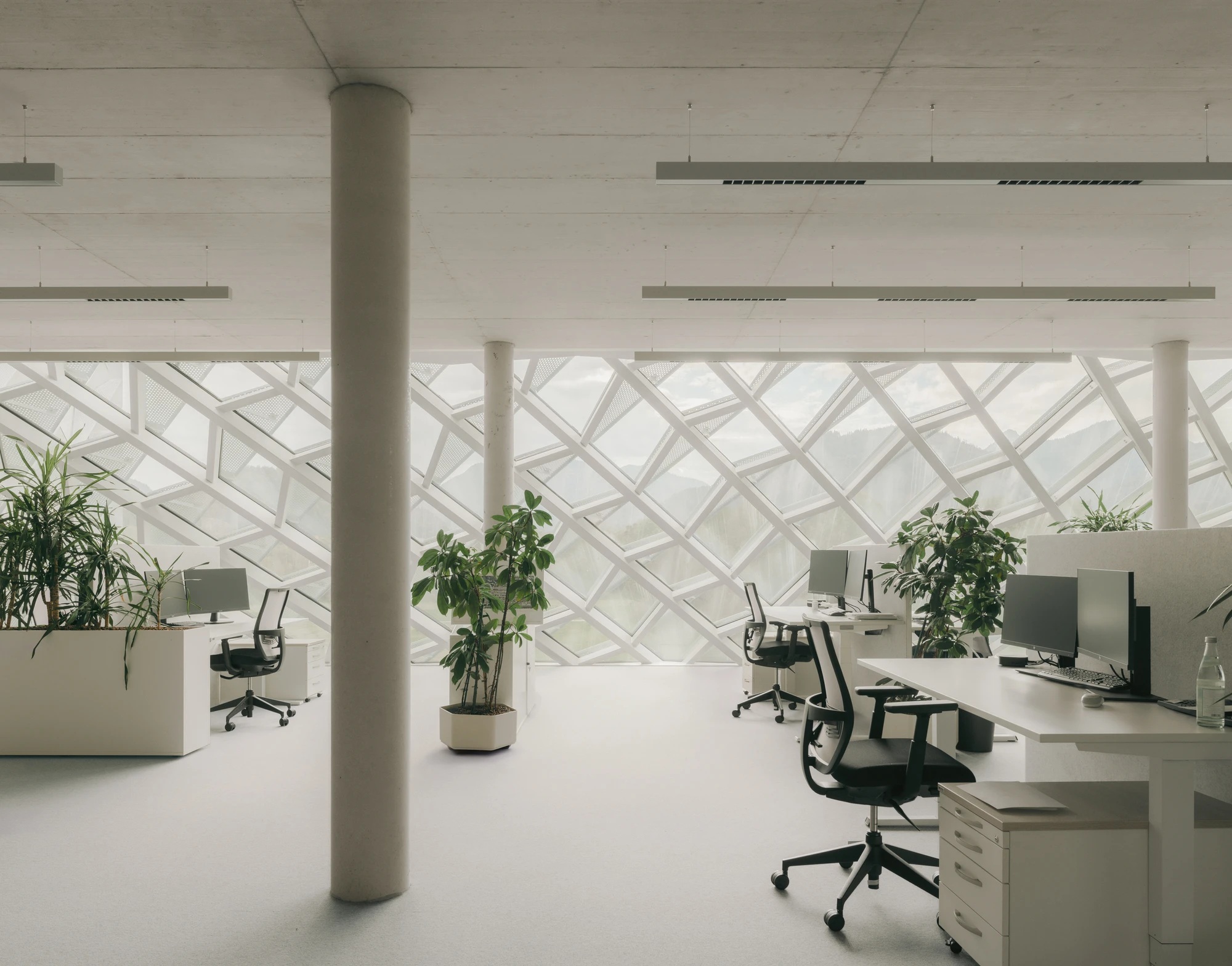 Dynafit Headquarters Speedfactory by Barozzi Veiga in Kiefersfelden Germany, twin pyramidal corporate building with diagonal metal lattice facade set against alpine landscape