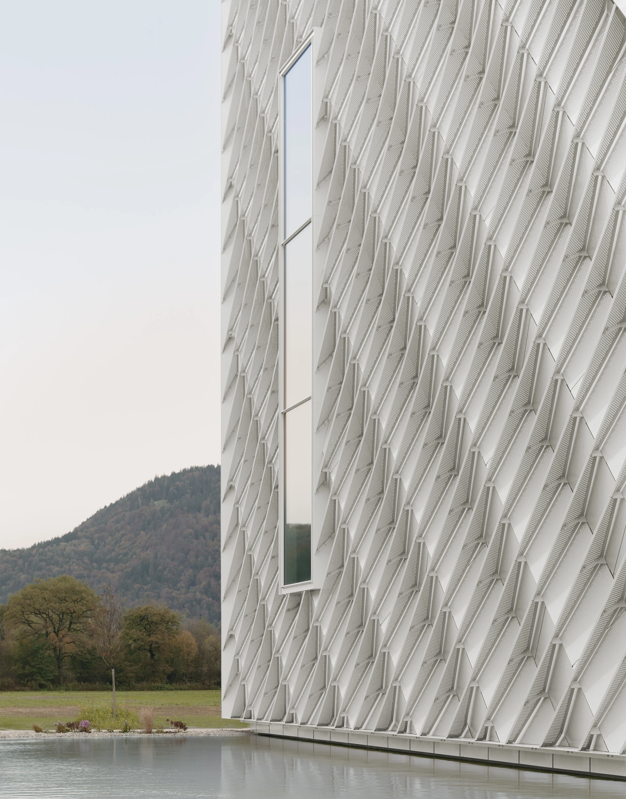 Dynafit Headquarters Speedfactory by Barozzi Veiga in Kiefersfelden Germany, twin pyramidal corporate building with diagonal metal lattice facade set against alpine landscape