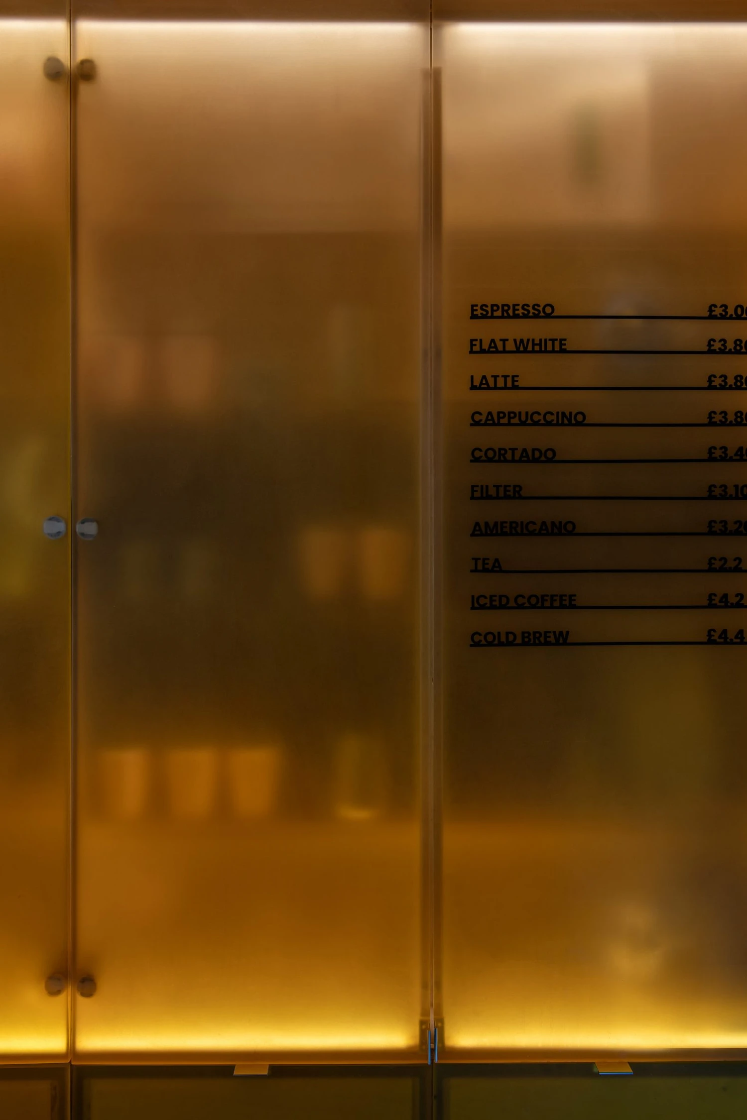 Joe Blake's Holborn coffee shop by EBBA in London tube station, minimalist interior with rounded stainless steel counter and milky translucent storage wall, sand-coloured plaster ceiling