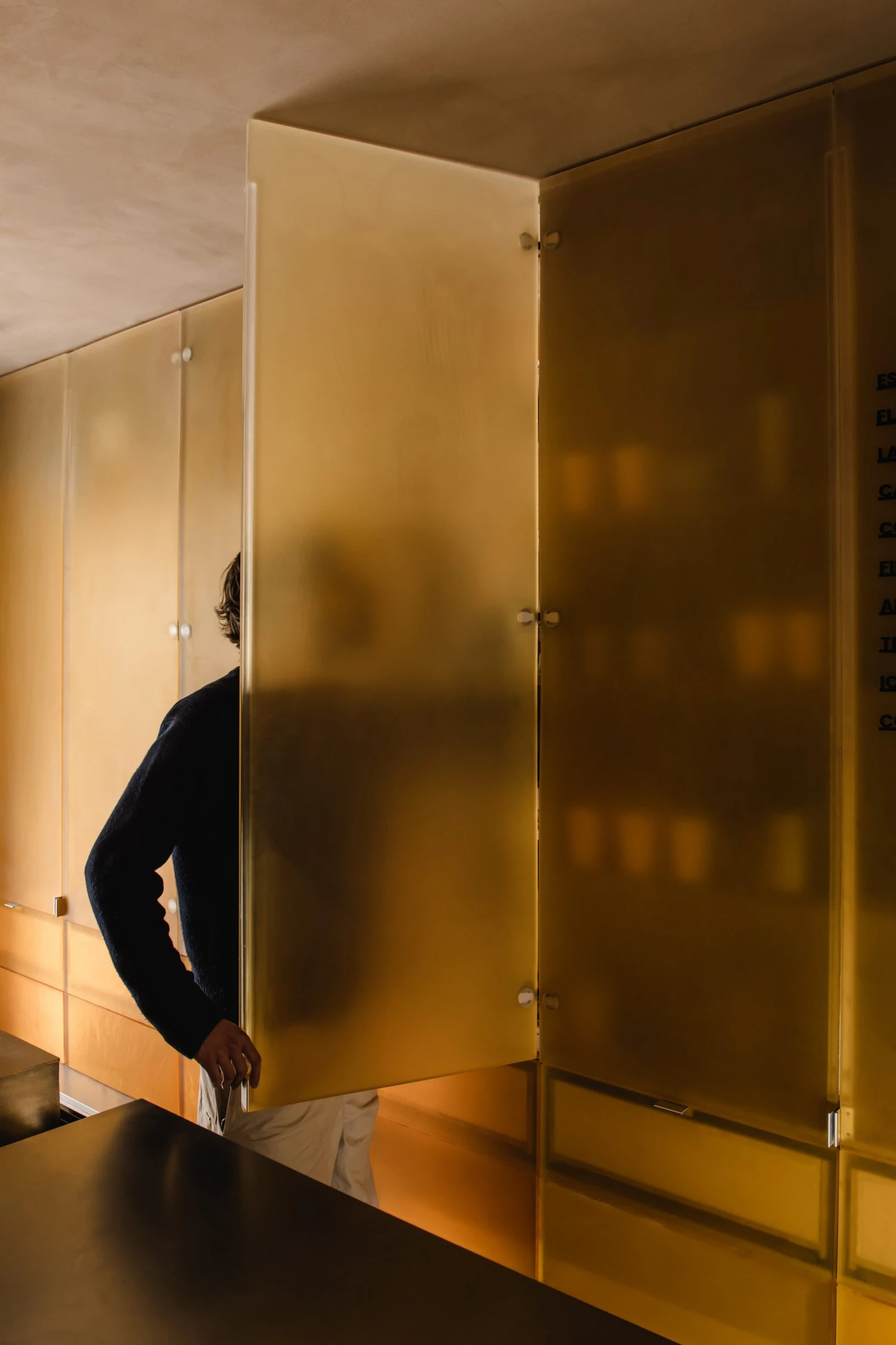 Joe Blake's Holborn coffee shop by EBBA in London tube station, minimalist interior with rounded stainless steel counter and milky translucent storage wall, sand-coloured plaster ceiling