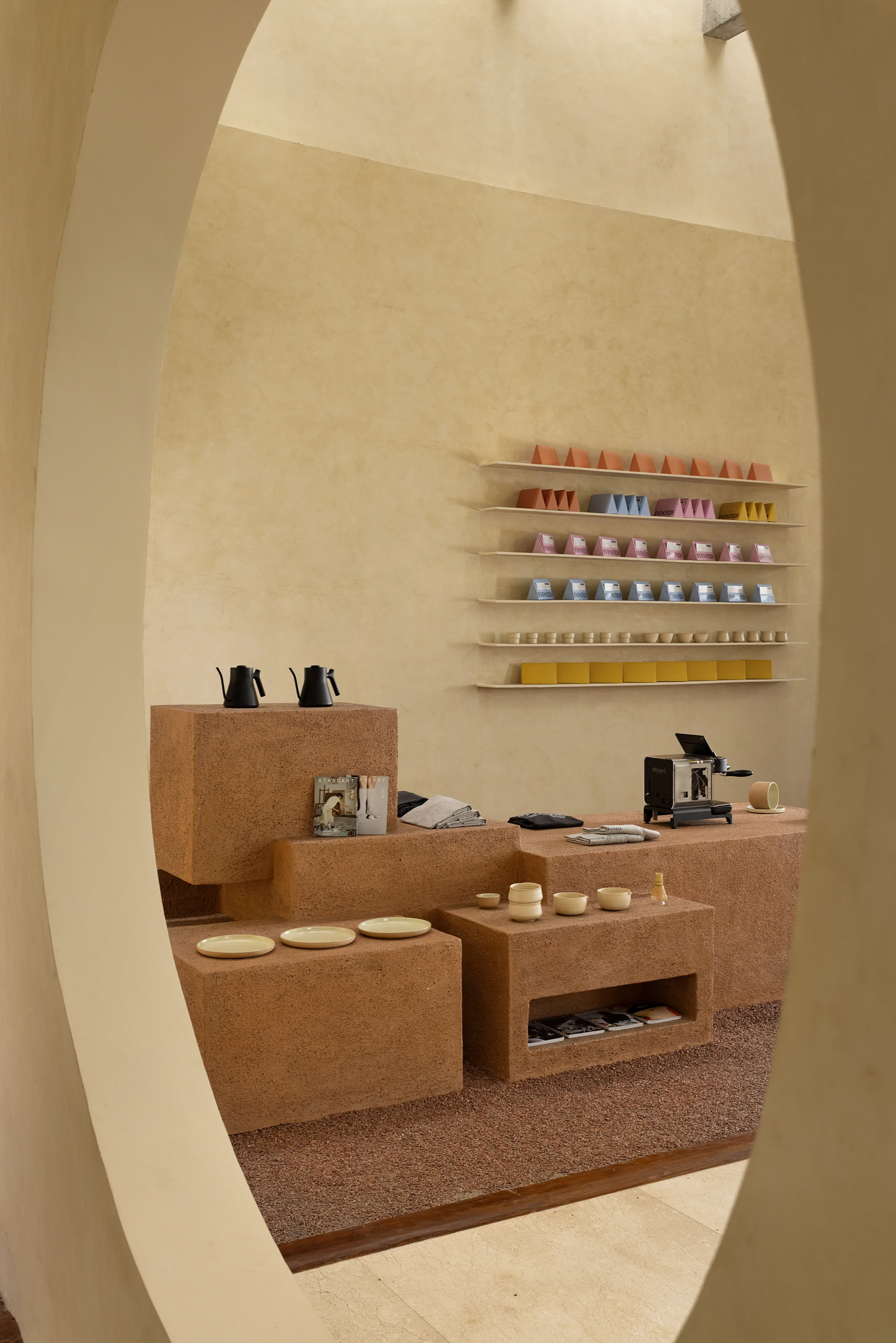 Eventide Coffee by BILLBOARDS in Chennai India, coastal cafe interior with elliptical counter and skylight, earthy tones and curved architectural elements inspired by the Madras beach