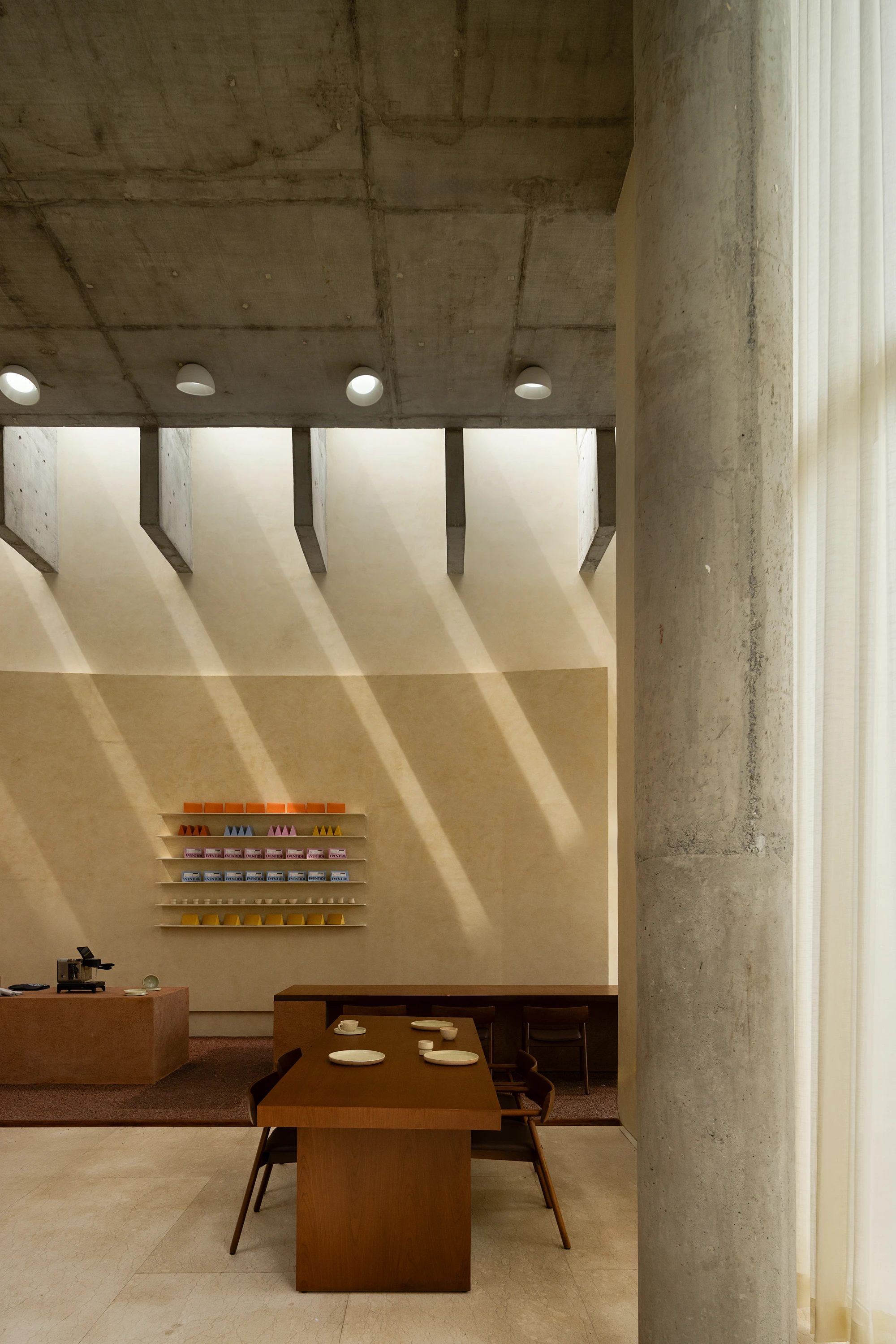 Eventide Coffee by BILLBOARDS in Chennai India, coastal cafe interior with elliptical counter and skylight, earthy tones and curved architectural elements inspired by the Madras beach