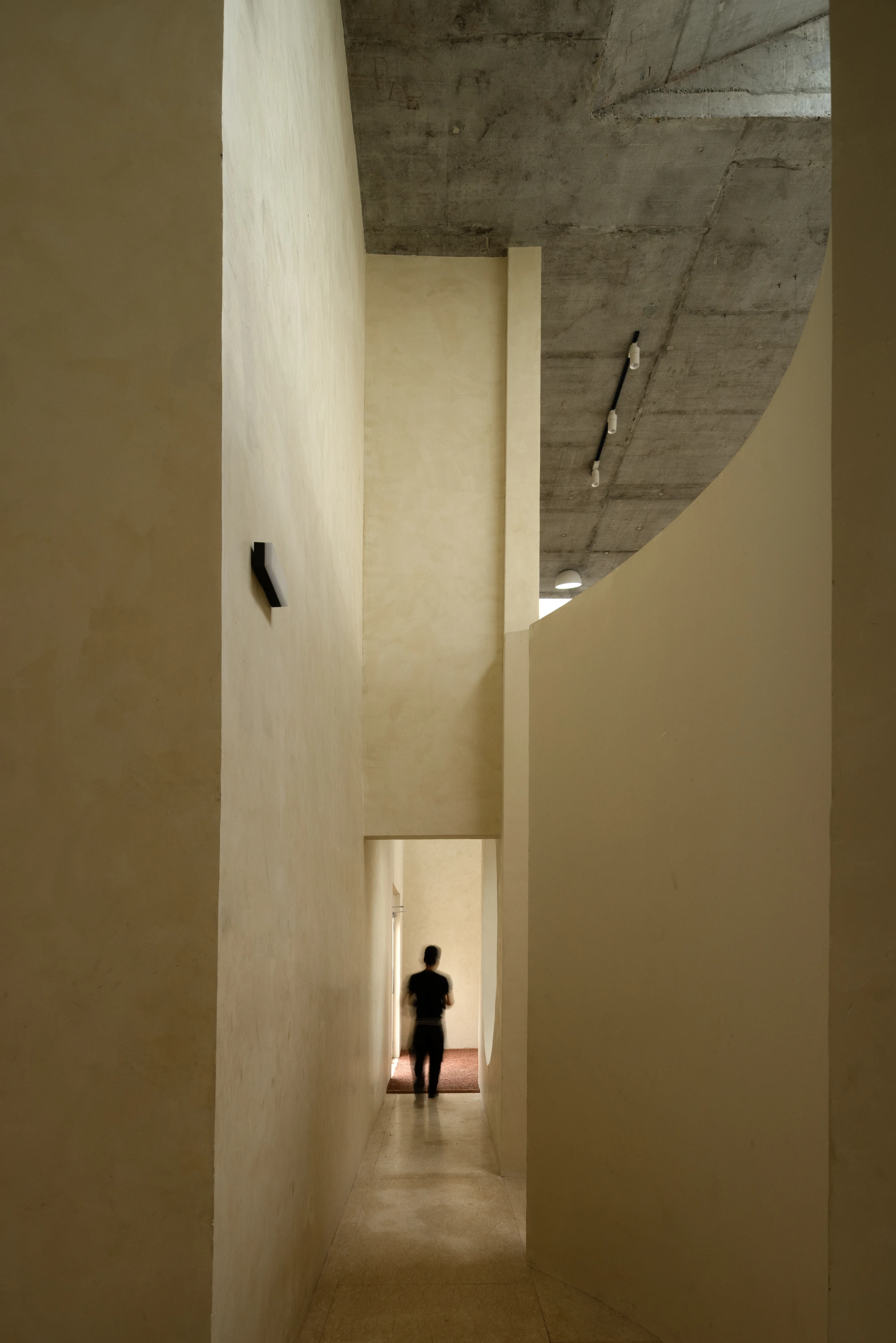 Eventide Coffee by BILLBOARDS in Chennai India, coastal cafe interior with elliptical counter and skylight, earthy tones and curved architectural elements inspired by the Madras beach