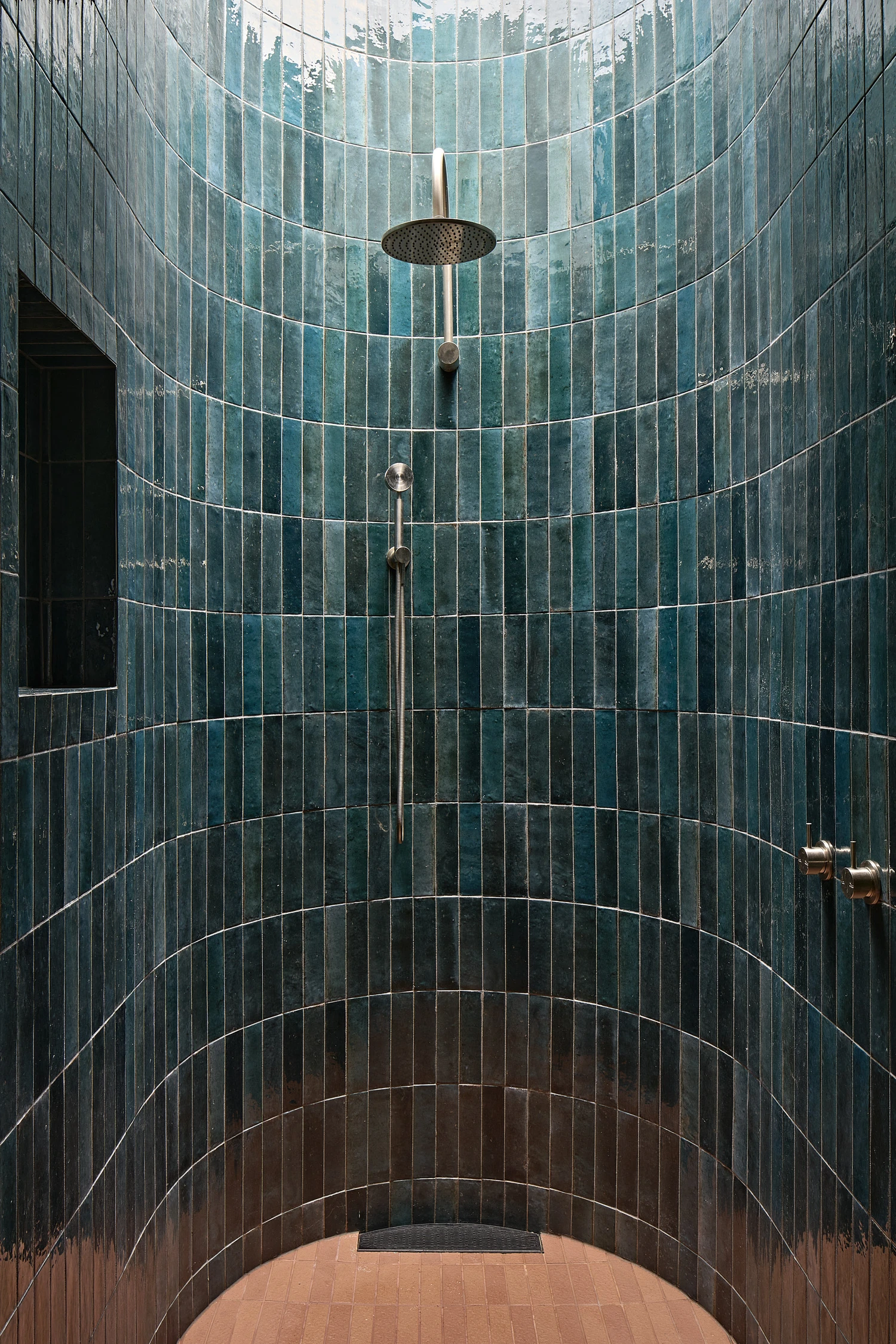 Homestead House by MRTN Architects — A cylindrical shower enclosure lined in vertically-grouted teal ceramic tiles demonstrates the material vocabulary of Homestead House's interior spaces.