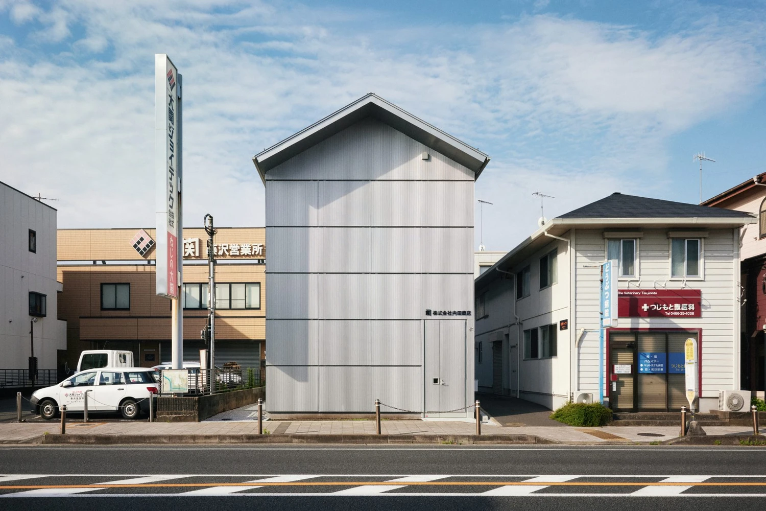 Uchida Shoten Head Office by Jo Nagasaka / Schemata Architects — Uchida Shoten's head office occupies a narrow street-front plot in Fujisawa, its pitch-roof form scaled to match neighboring residential buildings.