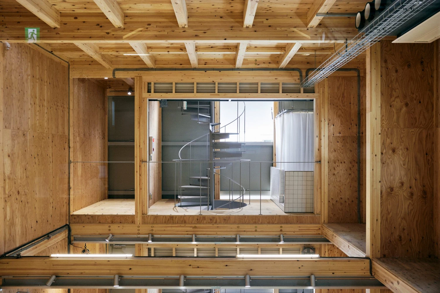 Uchida Shoten Head Office by Jo Nagasaka / Schemata Architects — Overhead view of the Uchida Shoten Head Office reveals the post-and-beam timber structure organizing the interior volume.