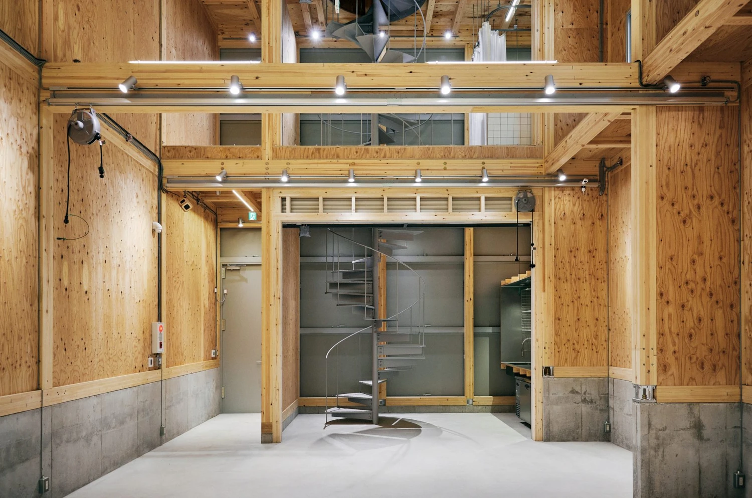 Uchida Shoten Head Office by Jo Nagasaka / Schemata Architects — Interior view of the Uchida Shoten Head Office reveals a double-height industrial workspace defined by post-and-beam timber construction and exposed...