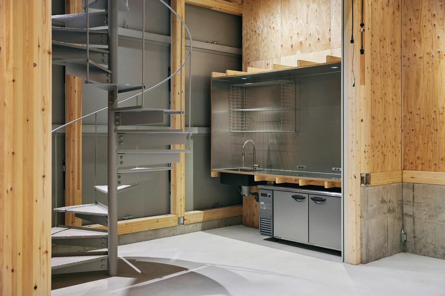 Uchida Shoten Head Office by Jo Nagasaka / Schemata Architects — Interior view of a compact kitchen and circulation space within the renovated Uchida Shoten head office.