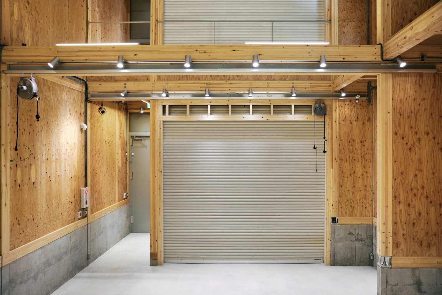 Uchida Shoten Head Office by Jo Nagasaka / Schemata Architects — The interior of Uchida Shoten's head office reveals a post-and-beam timber structural system with pine and plywood walls, the wood grain visible across the...