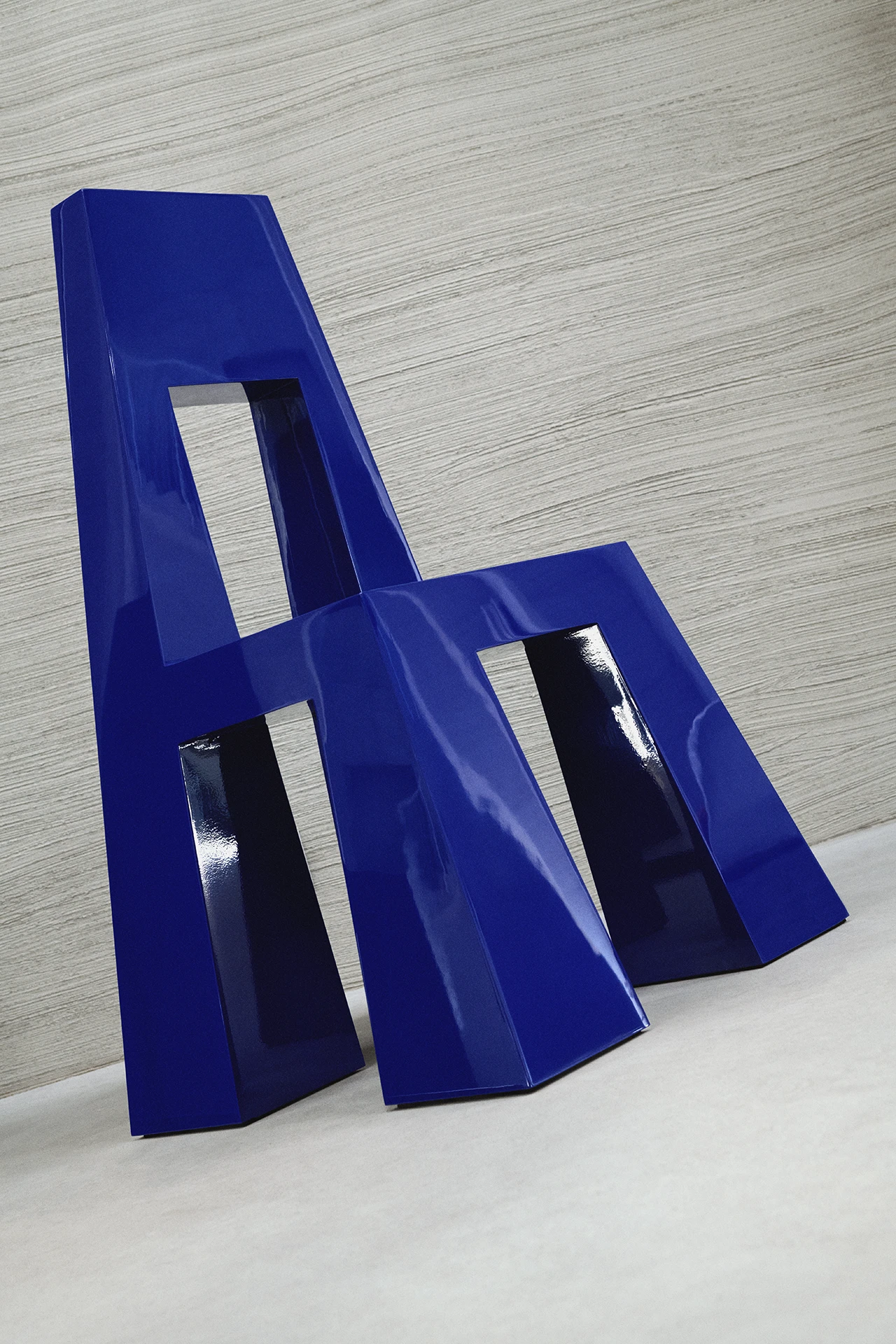 Fermo by Tobias Faisst — Fermo presents two stacked trapezoidal blue forms in ultramarine, angled to suggest seating proportions while maintaining deliberate spatial awkwardness.