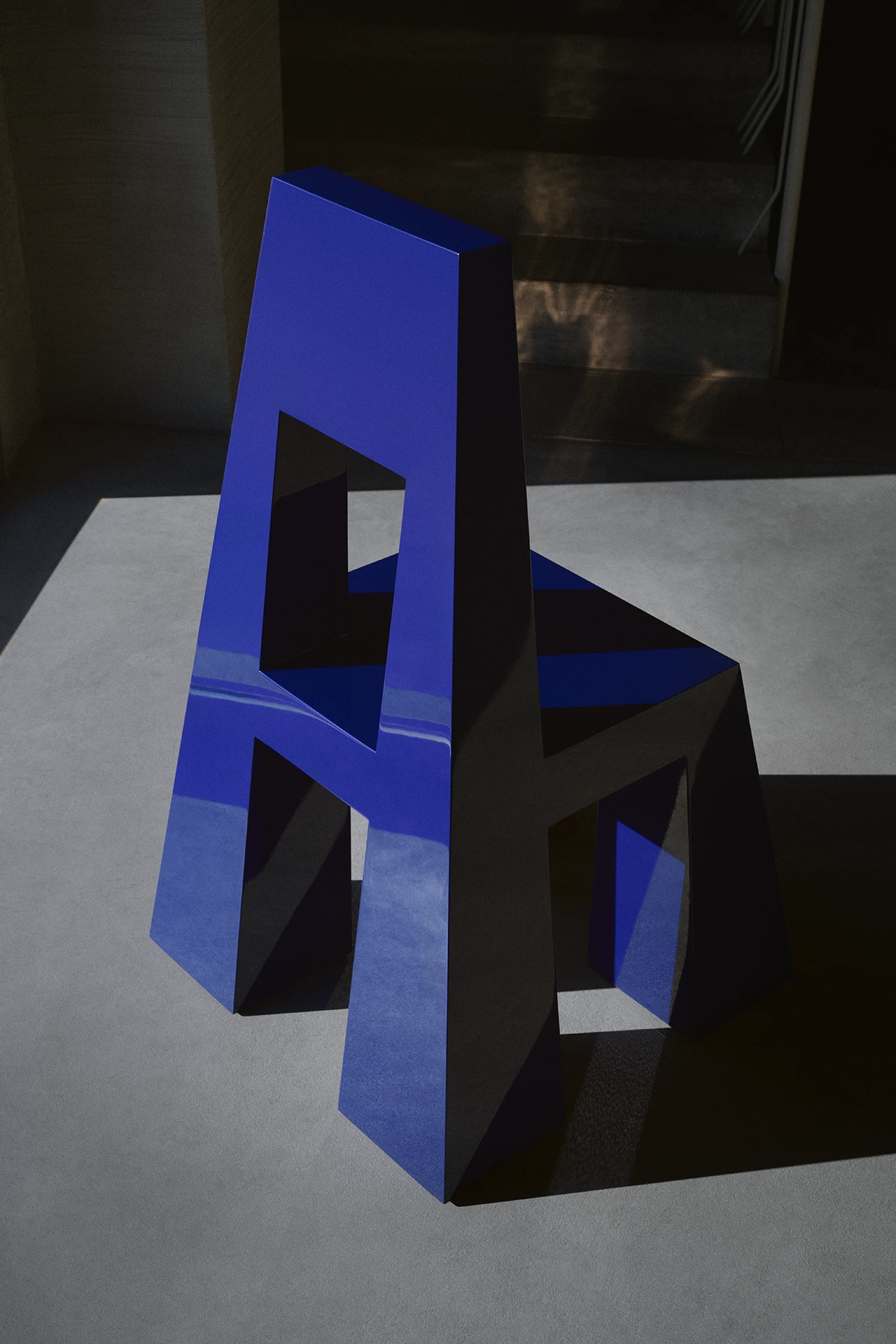 Fermo by Tobias Faisst — Fermo presents as a stacked sculptural object in electric ultramarine blue, composed of two trapezoidal forms with rectangular voids cut through their centers.