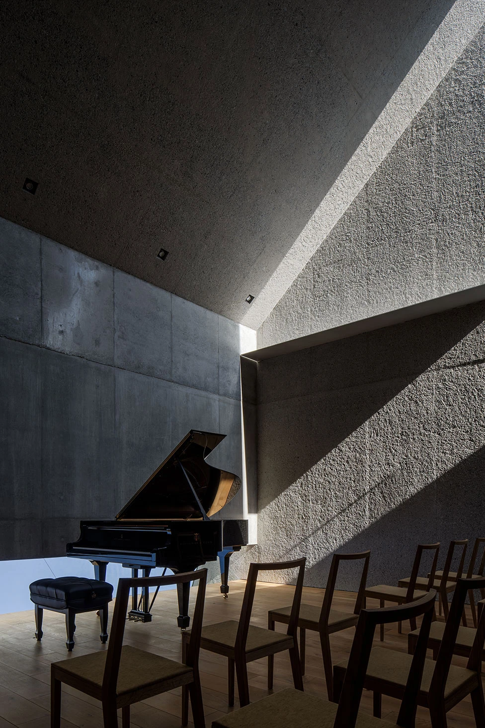 Music Hall in the Sky by Takuro Yamamoto Architects — A grand piano occupies the center of this 50-seat concert hall, positioned directly beneath an angular skylight that casts a geometric light shaft across...
