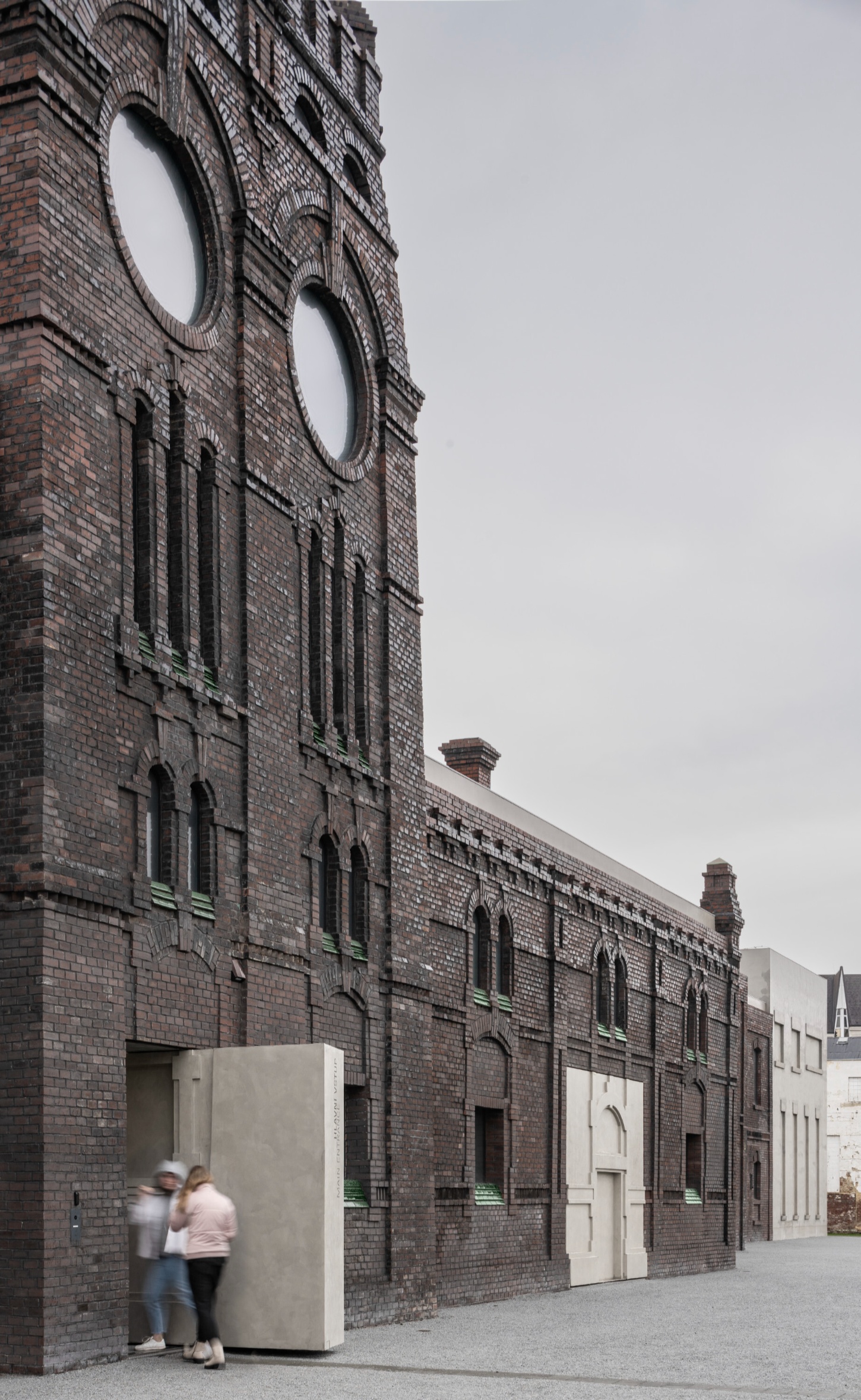 PLATO Contemporary Art Gallery by KWK PROMES — A micro-concrete pavilion with rectilinear geometry occupies the brick opening of a heritage industrial building.