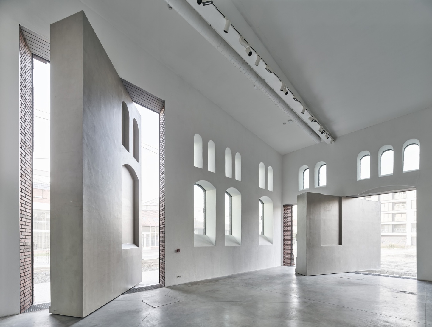 PLATO Contemporary Art Gallery by KWK PROMES — A double-height gallery interior reveals the architectural strategy of material contrast and geometric intervention.