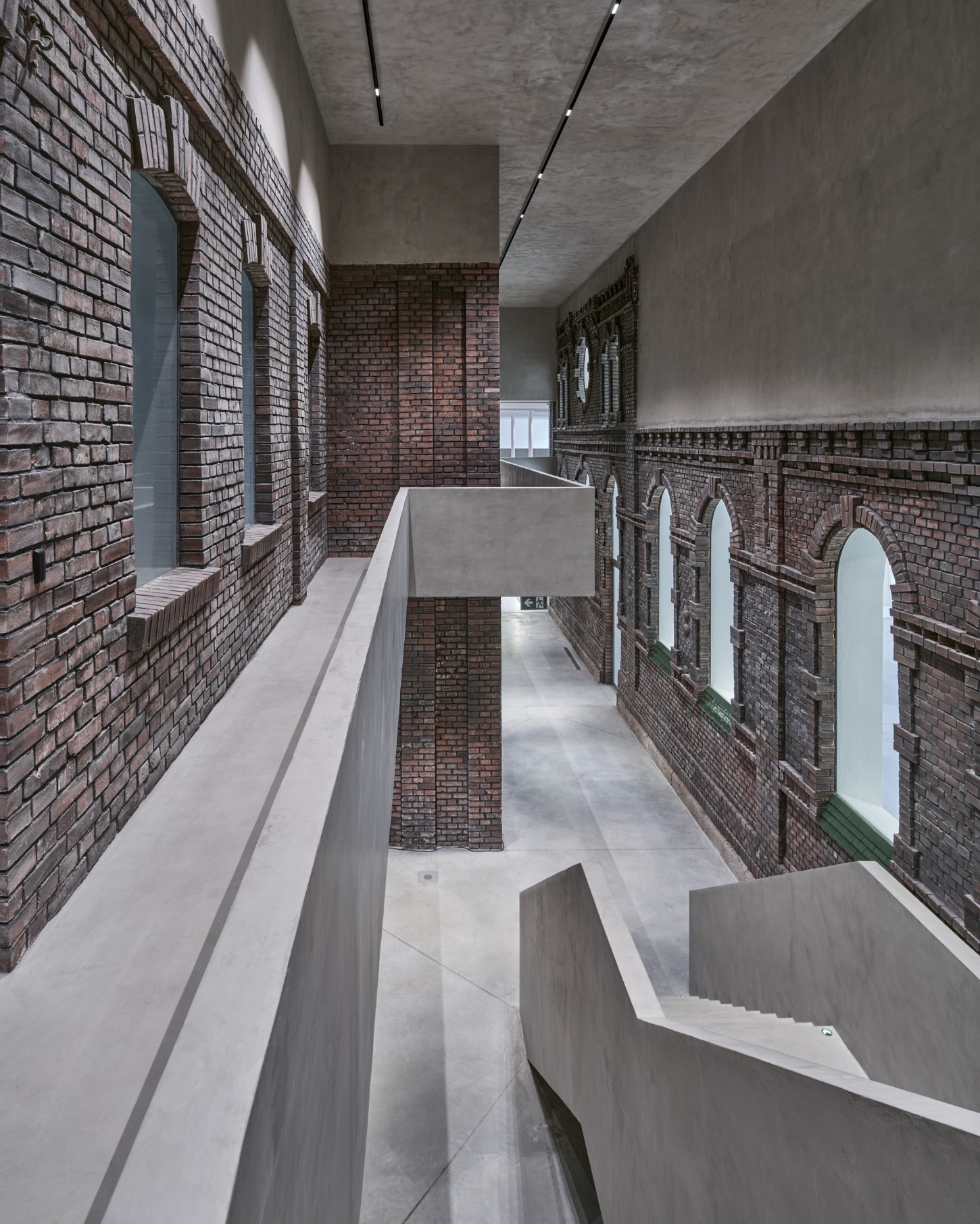 PLATO Contemporary Art Gallery by KWK PROMES — A narrow interior corridor defined by the collision of two material epochs.