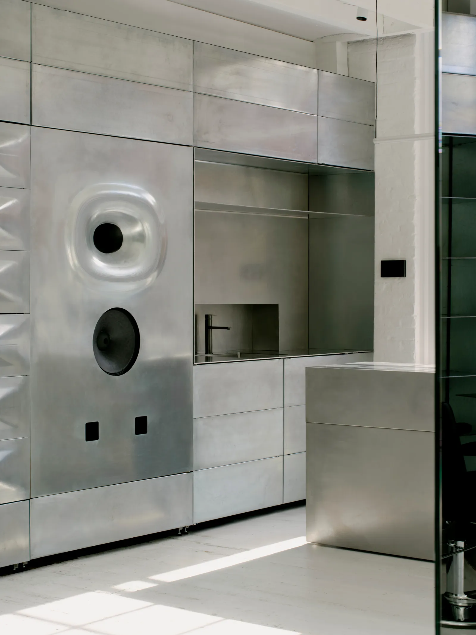 Salt Salon by unknown works — A shower enclosure clad entirely in large-format ceramic tiles arranged in horizontal registers, creating a rhythmic striped pattern across the wall plane.
