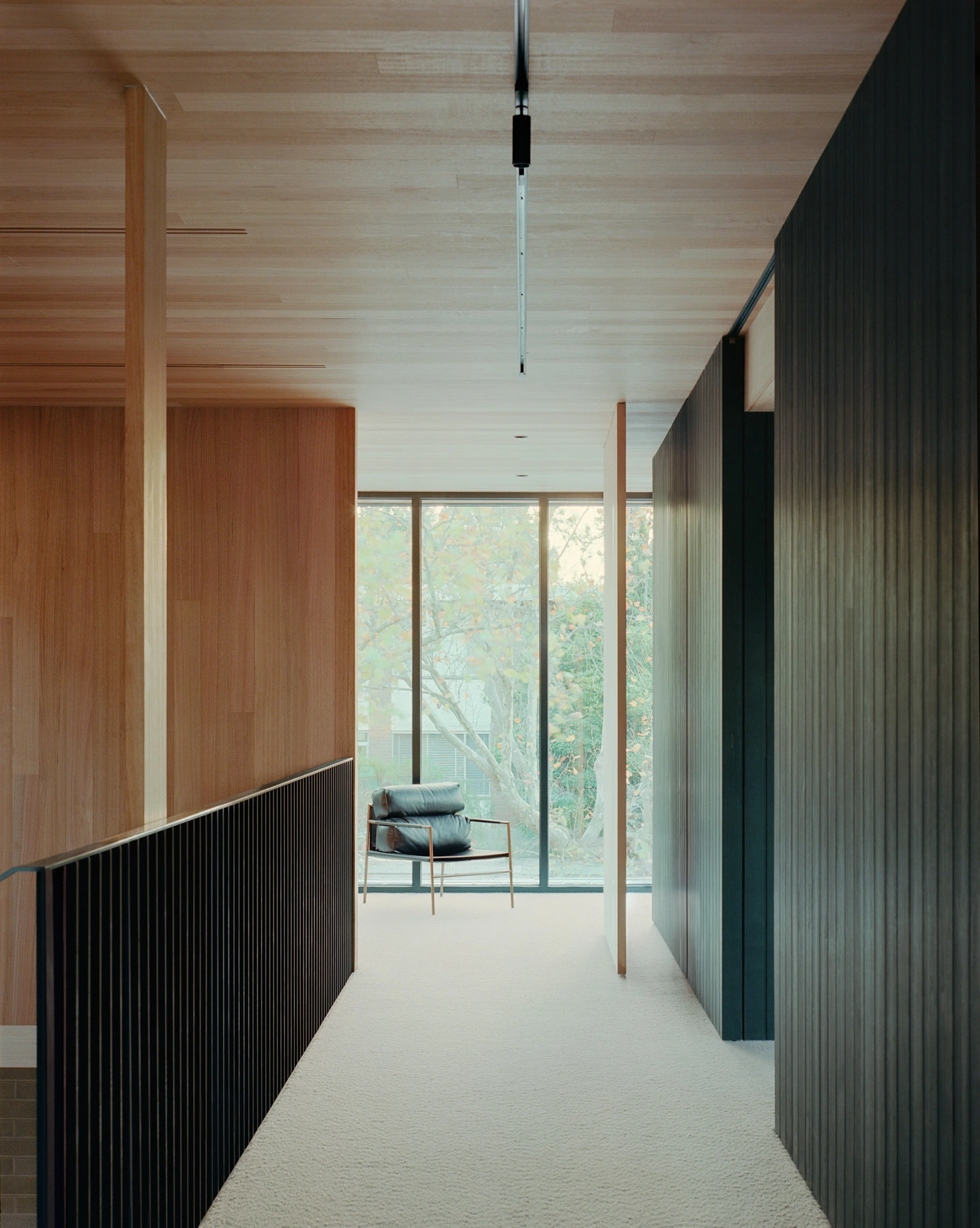 Echo House by Parabolica — A corridor view through Echo House reveals the considered material palette and spatial layering.