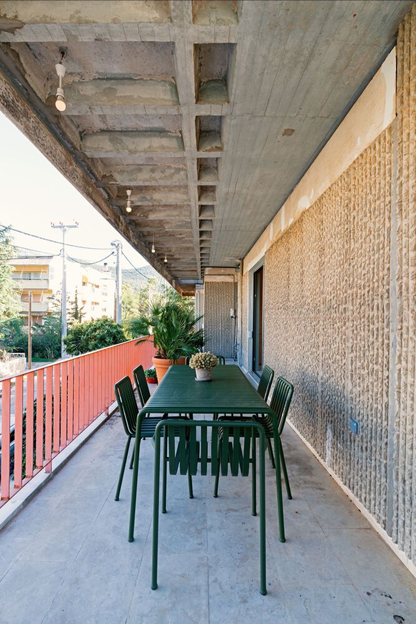 Three Object Apartment by DeMachinas + Elina Loukou — A cantilevered concrete soffit extends over the outdoor dining terrace, its underside articulated by a regular grid of recessed coffers and embedded...