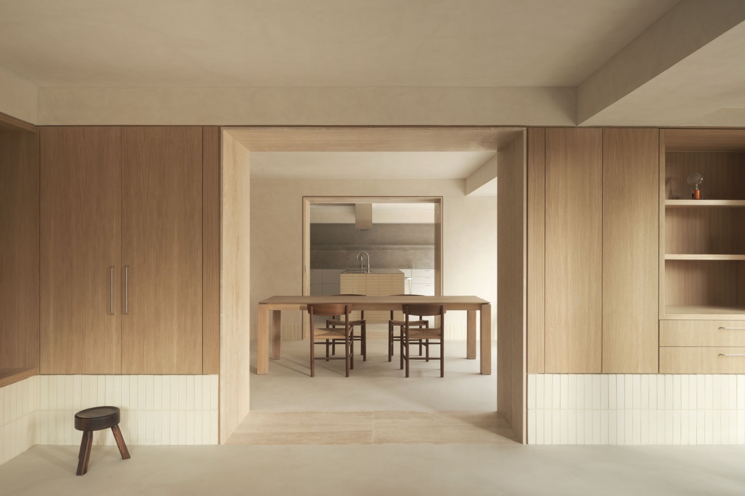 Casa SO by Studio DIIR — A timber-lined passage frames the domestic interior of Casa SO, where vertical wood grain paneling in warm oak tones meets white plaster walls.
