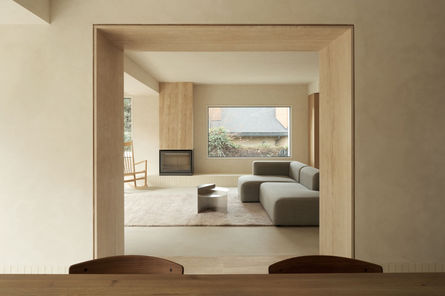 Casa SO by Studio DIIR — View through a timber-framed threshold into a living room flooded with natural light.